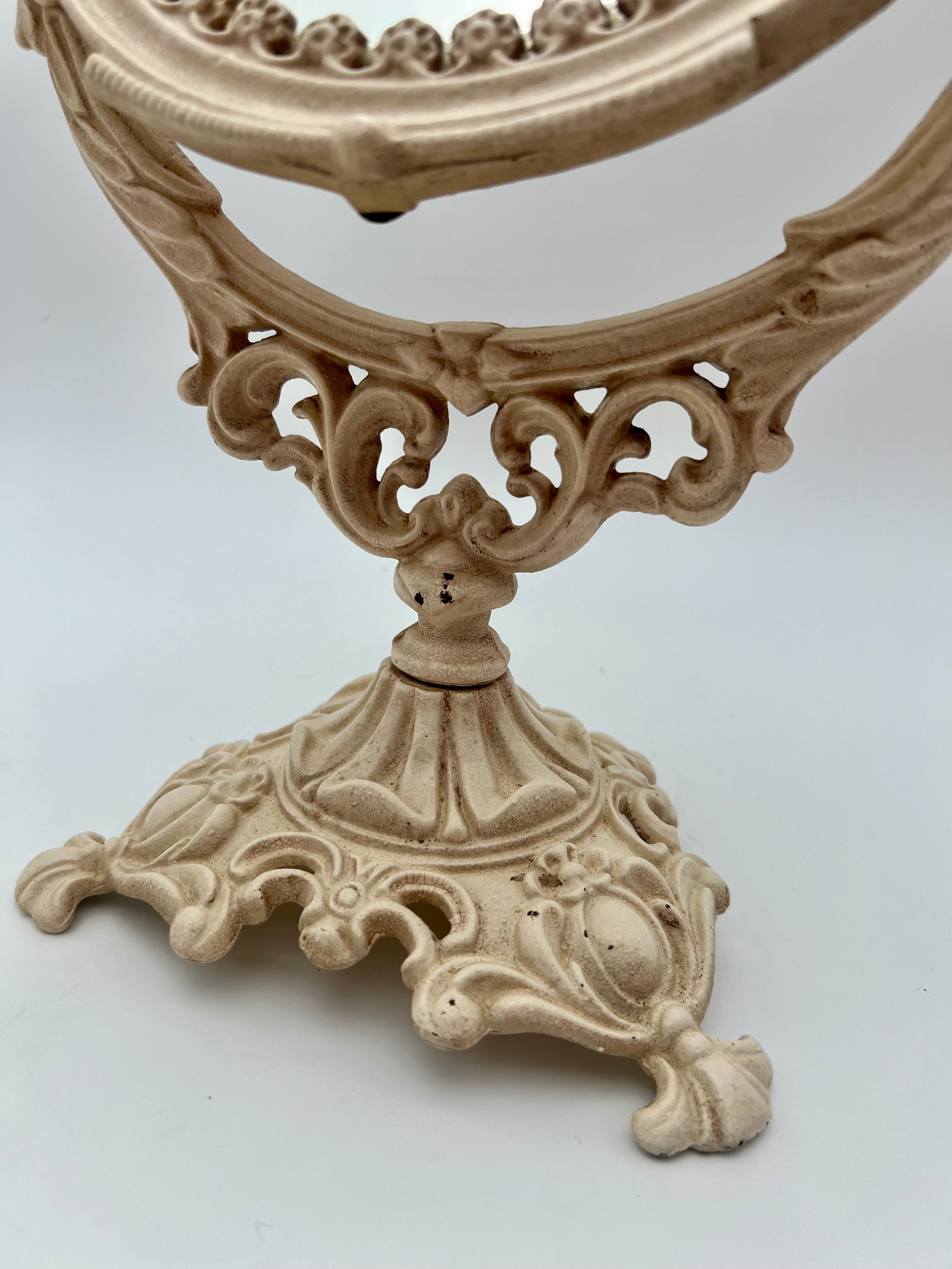 ANTIQUE VANITY TABLE MIRROR WITH DOG HEAD HANDLES & PUTTO CHERUB – ORNATE CAST IRON – 14 ¾ INCH – CIRCA EARLY 1900s