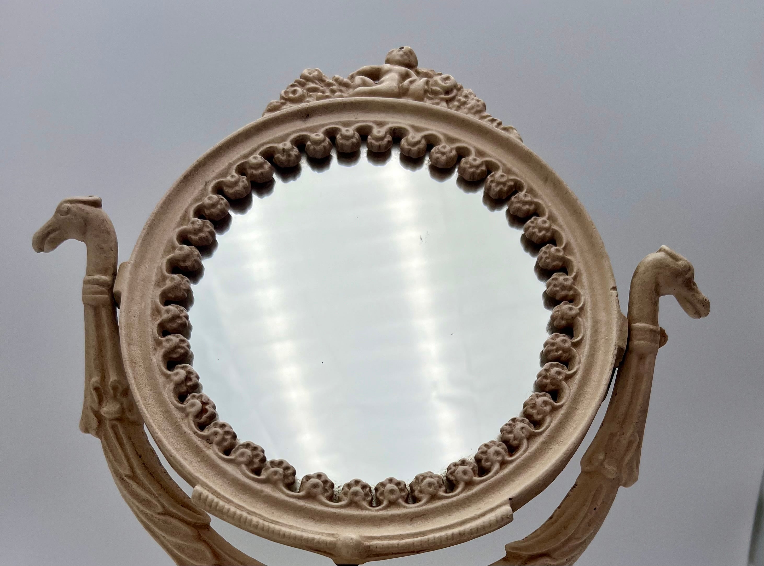 ANTIQUE VANITY TABLE MIRROR WITH DOG HEAD HANDLES & PUTTO CHERUB – ORNATE CAST IRON – 14 ¾ INCH – CIRCA EARLY 1900s