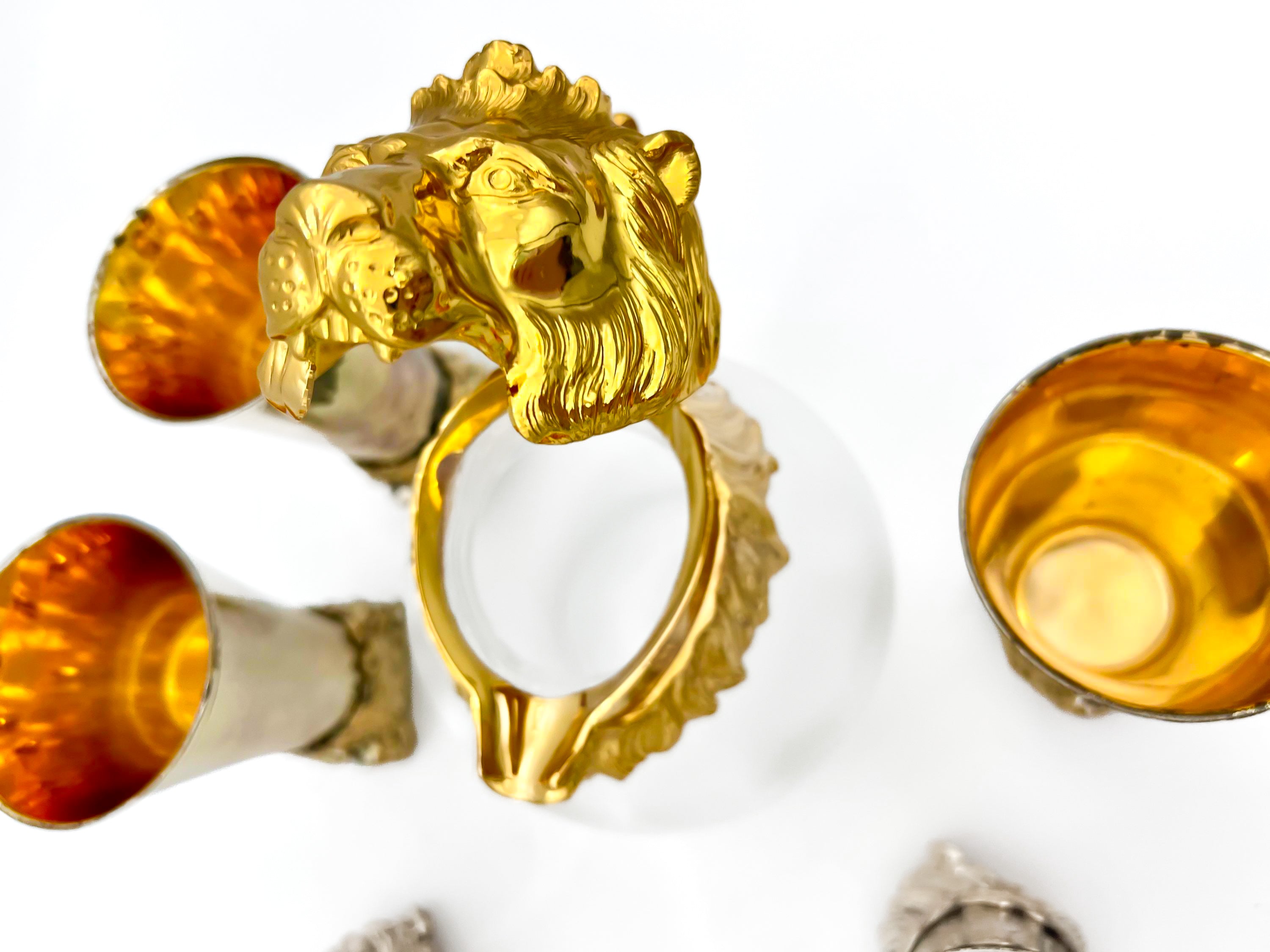 Rare set of 7 Carole Stupell mid-century barware featuring a glass pitcher and stirrup cups with silver-toned lion head bases.