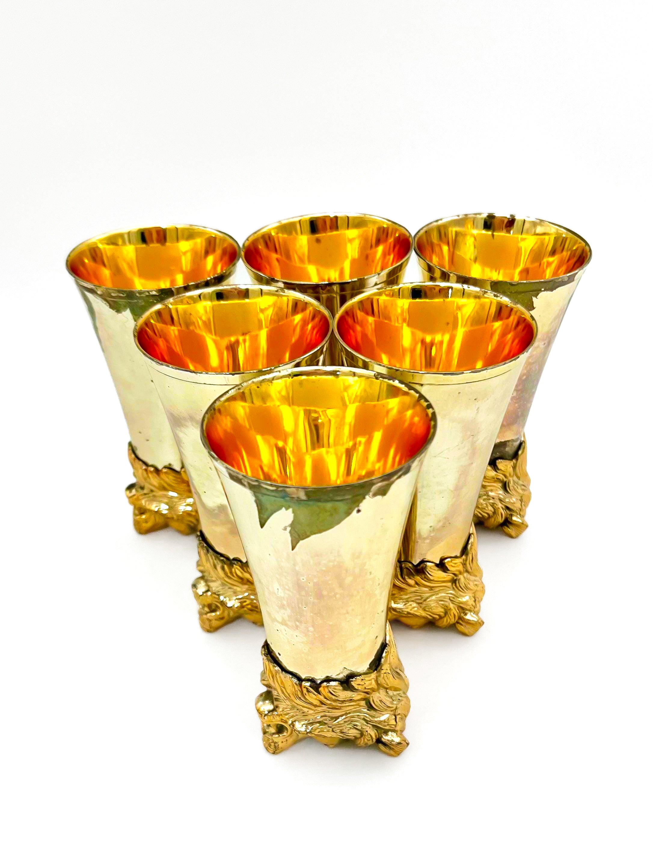 Rare set of 7 Carole Stupell mid-century barware featuring a glass pitcher and stirrup cups with silver-toned lion head bases.