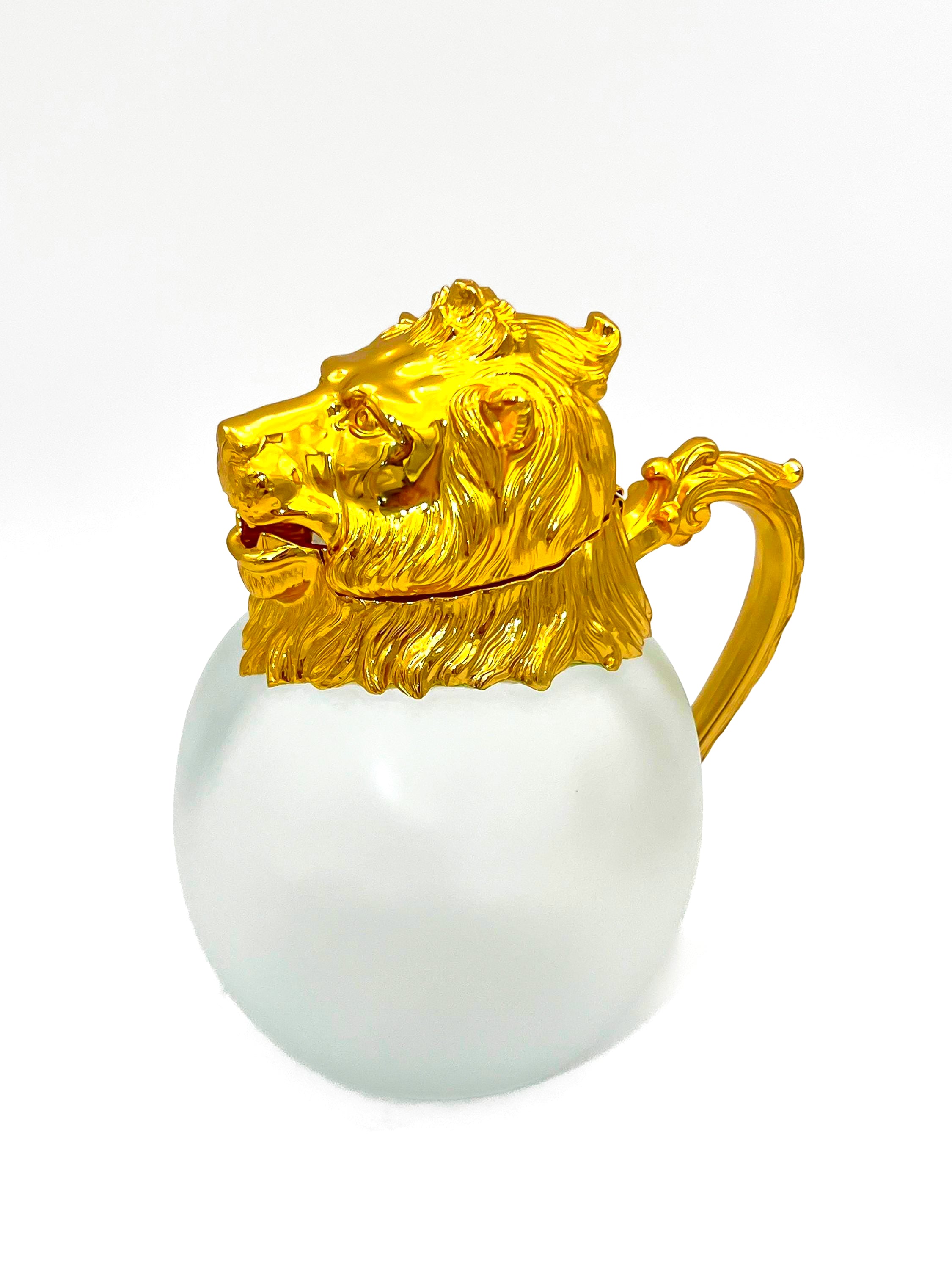 Rare set of 7 Carole Stupell mid-century barware featuring a glass pitcher and stirrup cups with silver-toned lion head bases.