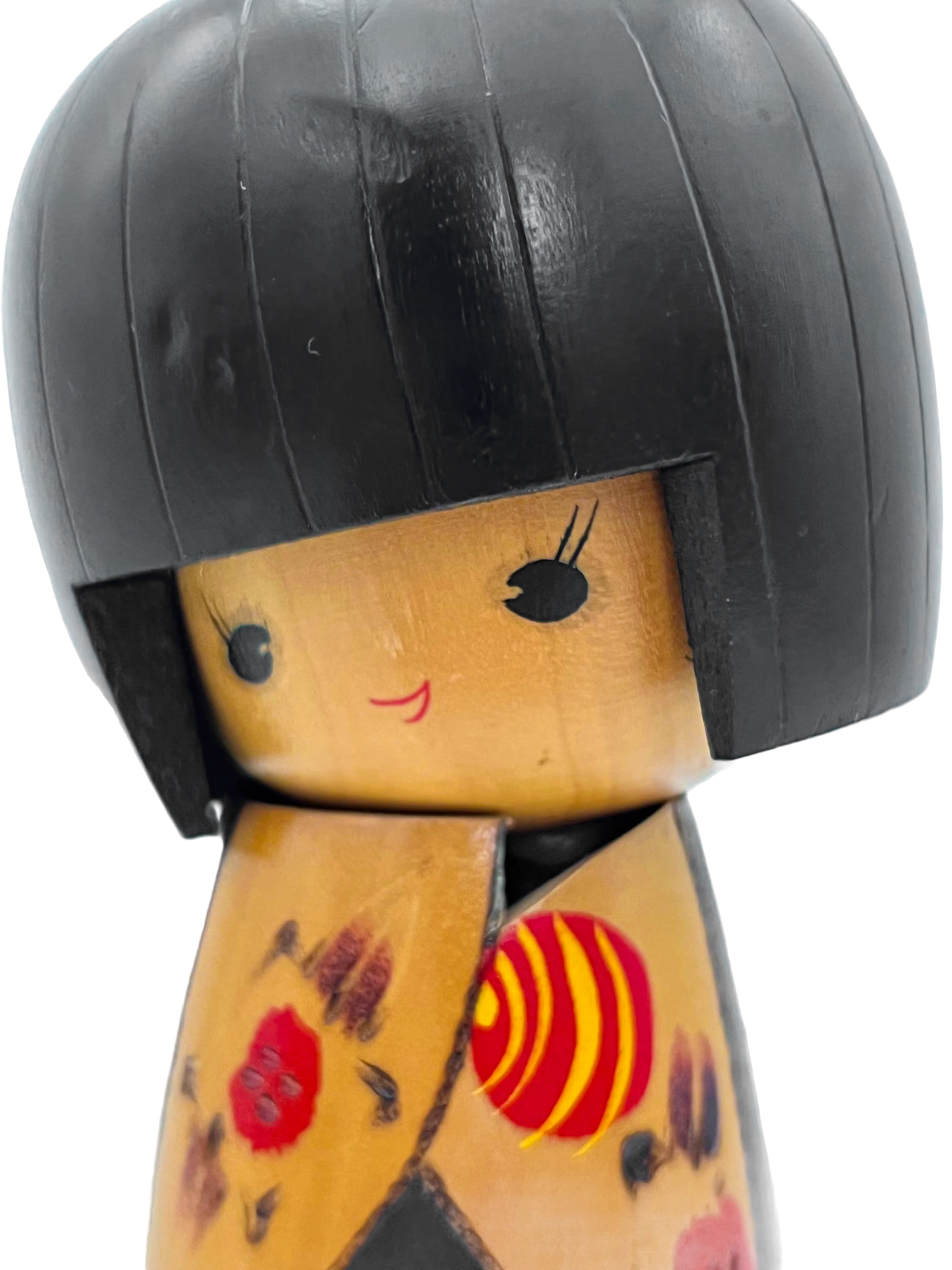 Traditional vintage Japanese Kokeshi doll made of hand-painted wood with floral accents.
