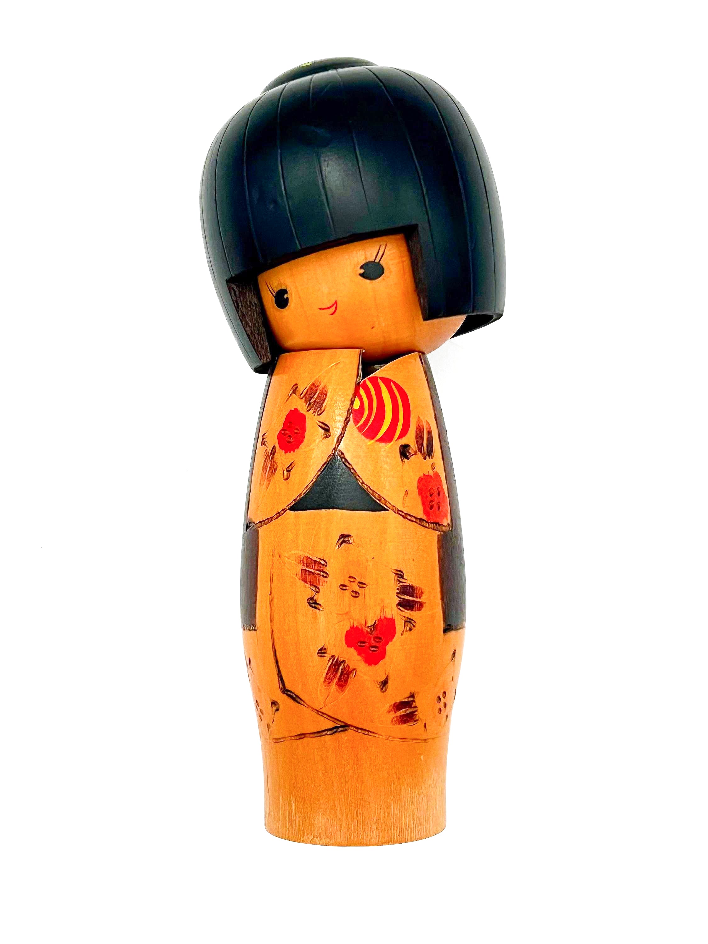 Traditional vintage Japanese Kokeshi doll made of hand-painted wood with floral accents.
