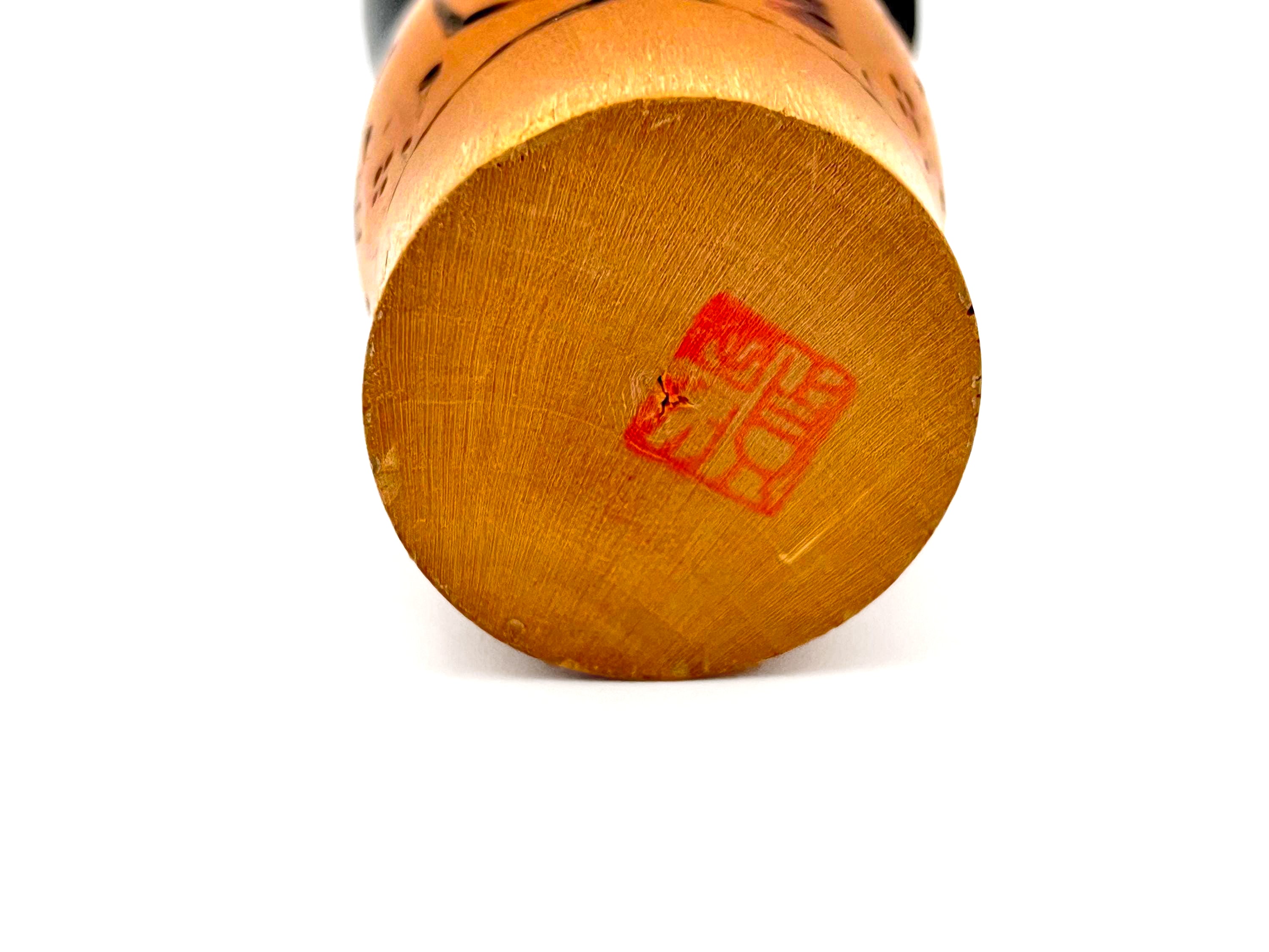 Traditional vintage Japanese Kokeshi doll made of hand-painted wood with floral accents.