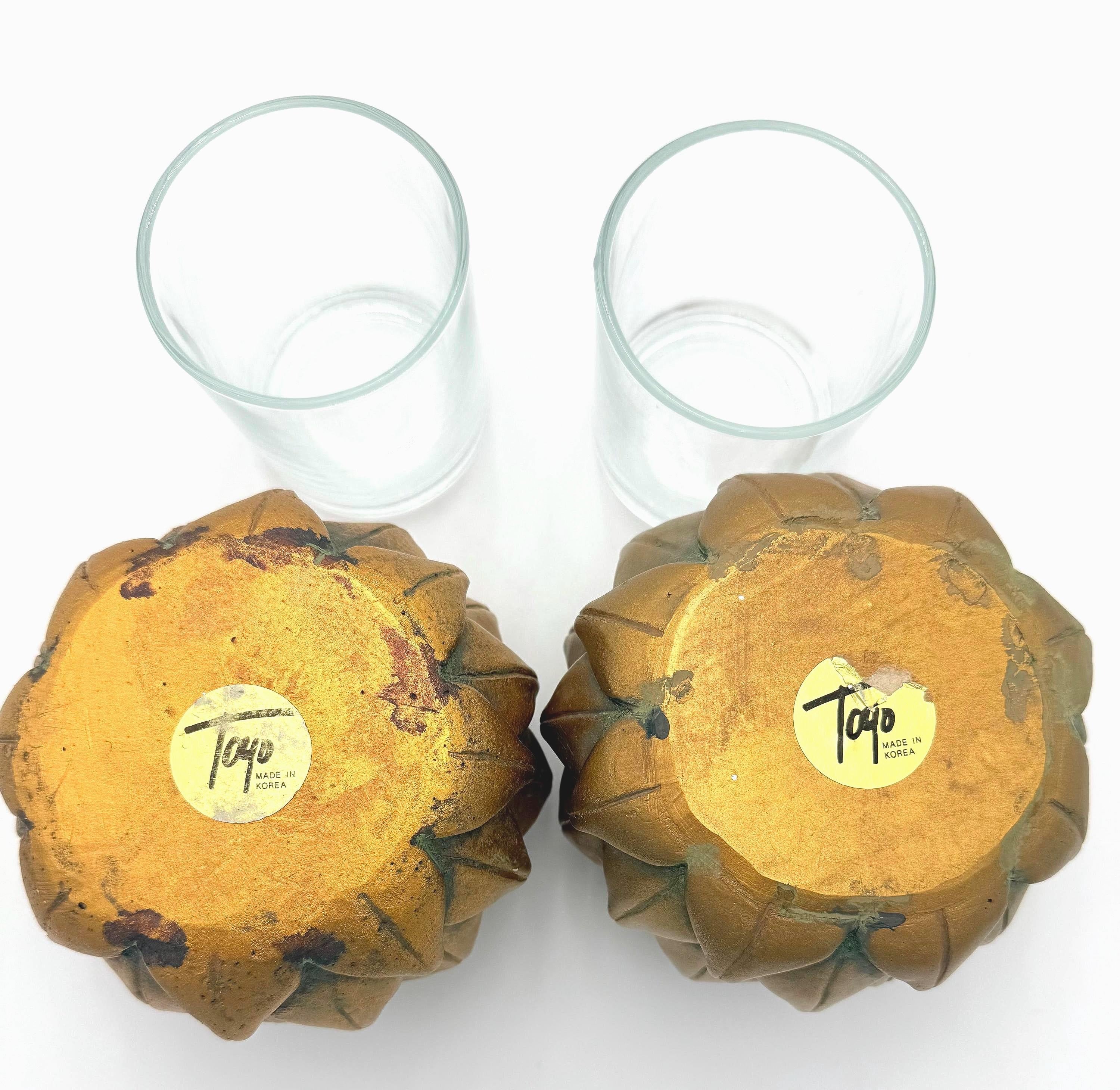 Pair of heavy vintage votive holders shaped like golden artichokes with a metallic finish.