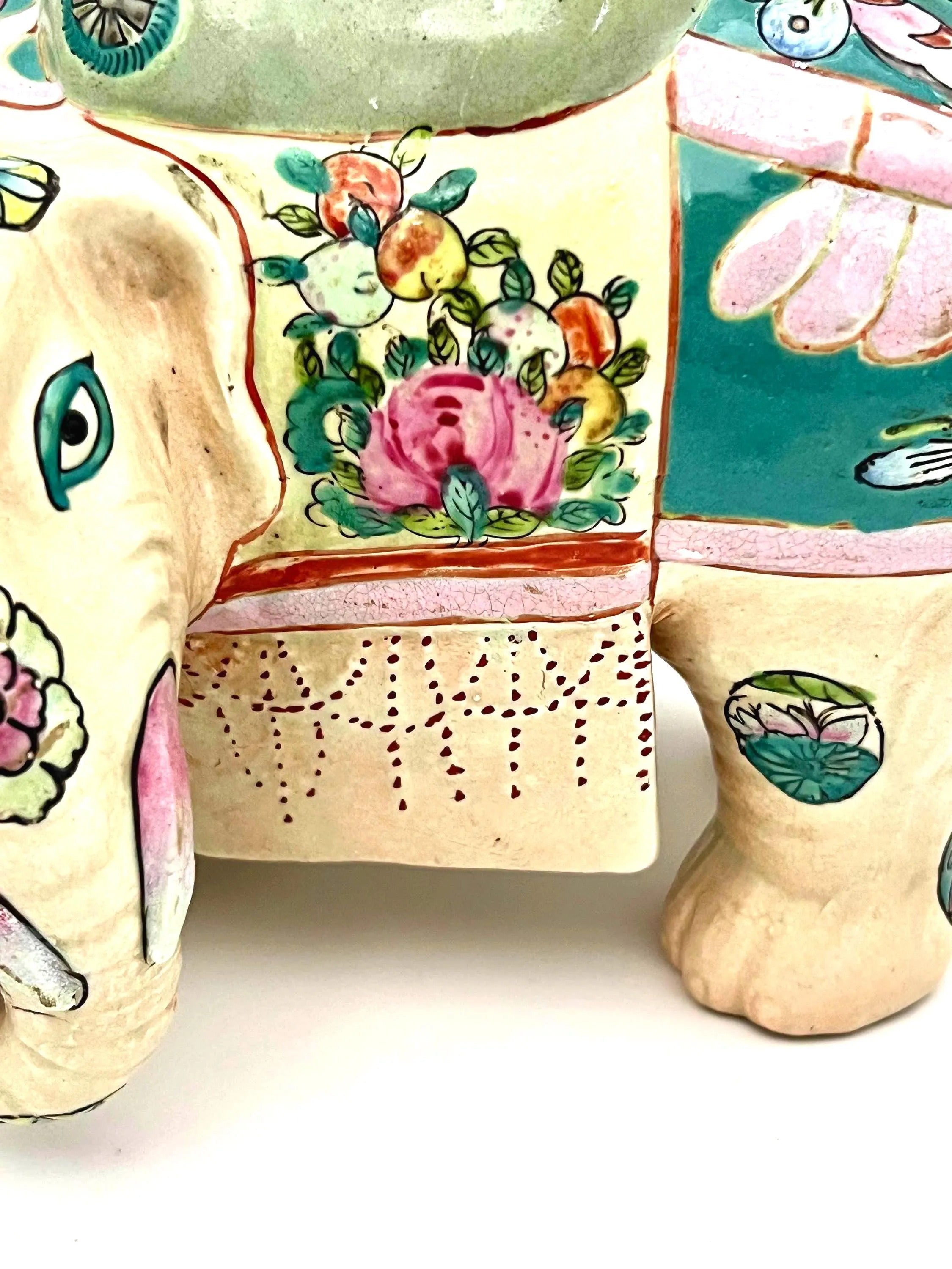 Hand-painted antique Chinese porcelain elephant candleholder with an ornate saddle and floral motifs.
