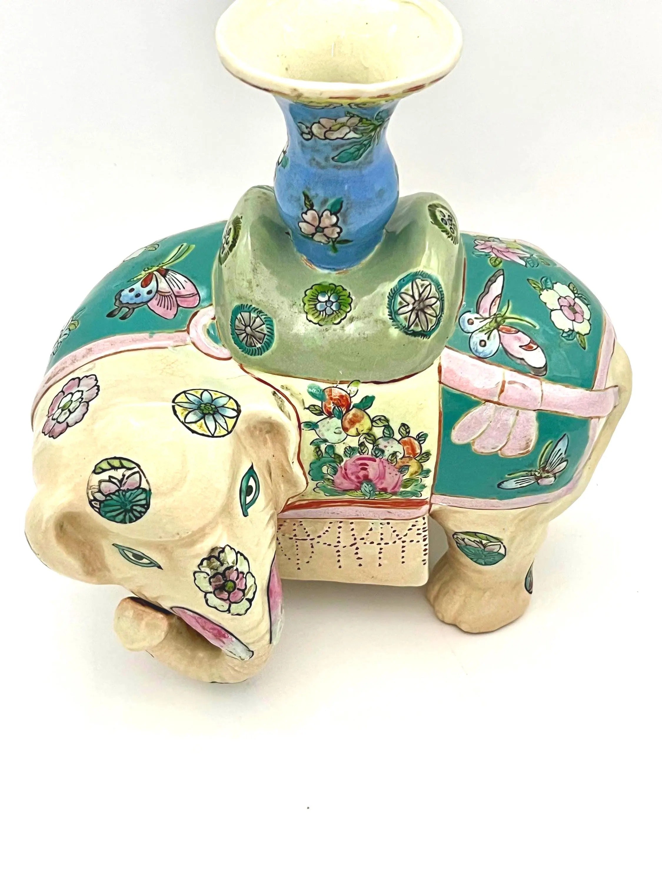 Hand-painted antique Chinese porcelain elephant candleholder with an ornate saddle and floral motifs.