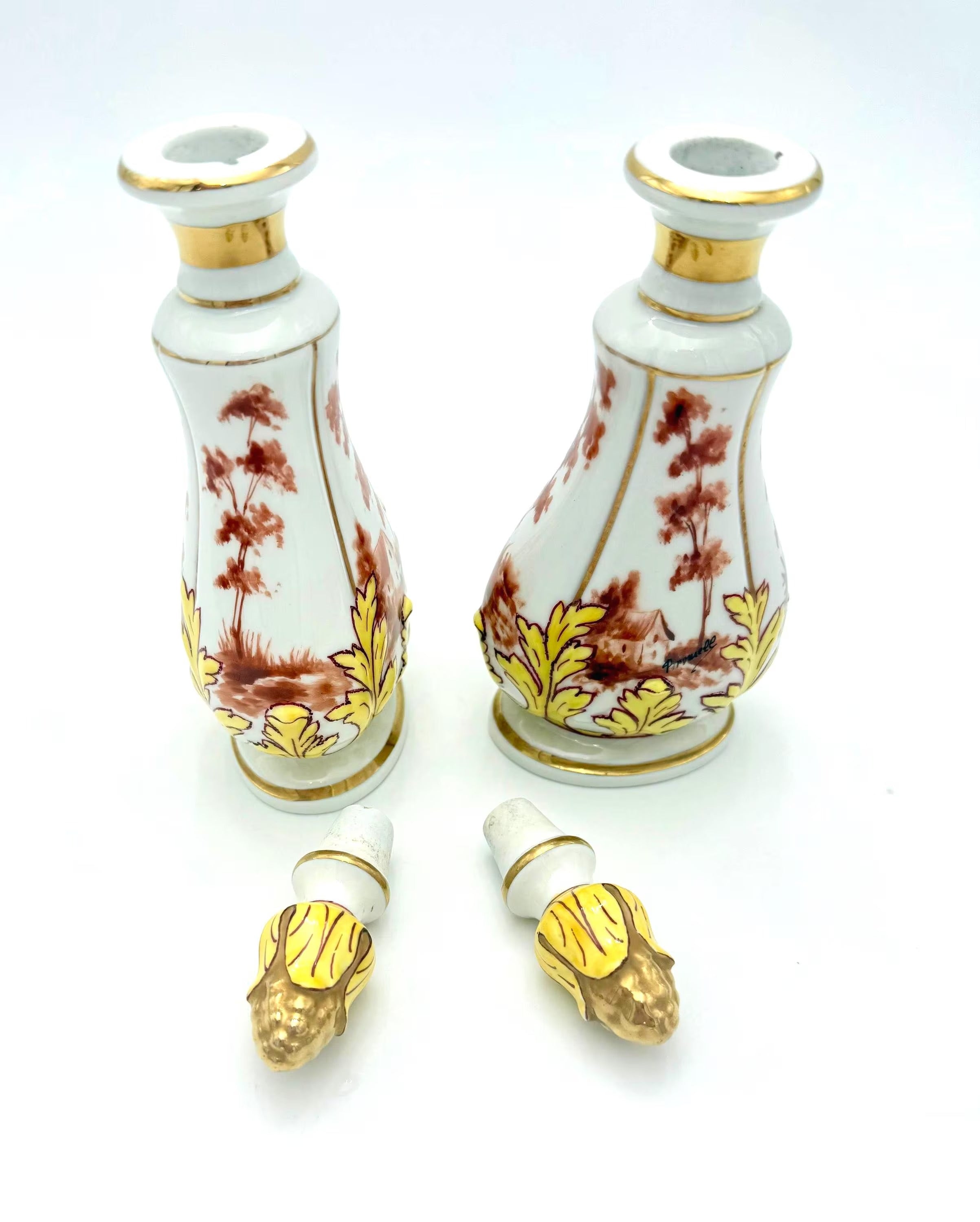 Pair of 19th-century French porcelain cologne bottles with intricate hand-painted Victorian scenes.