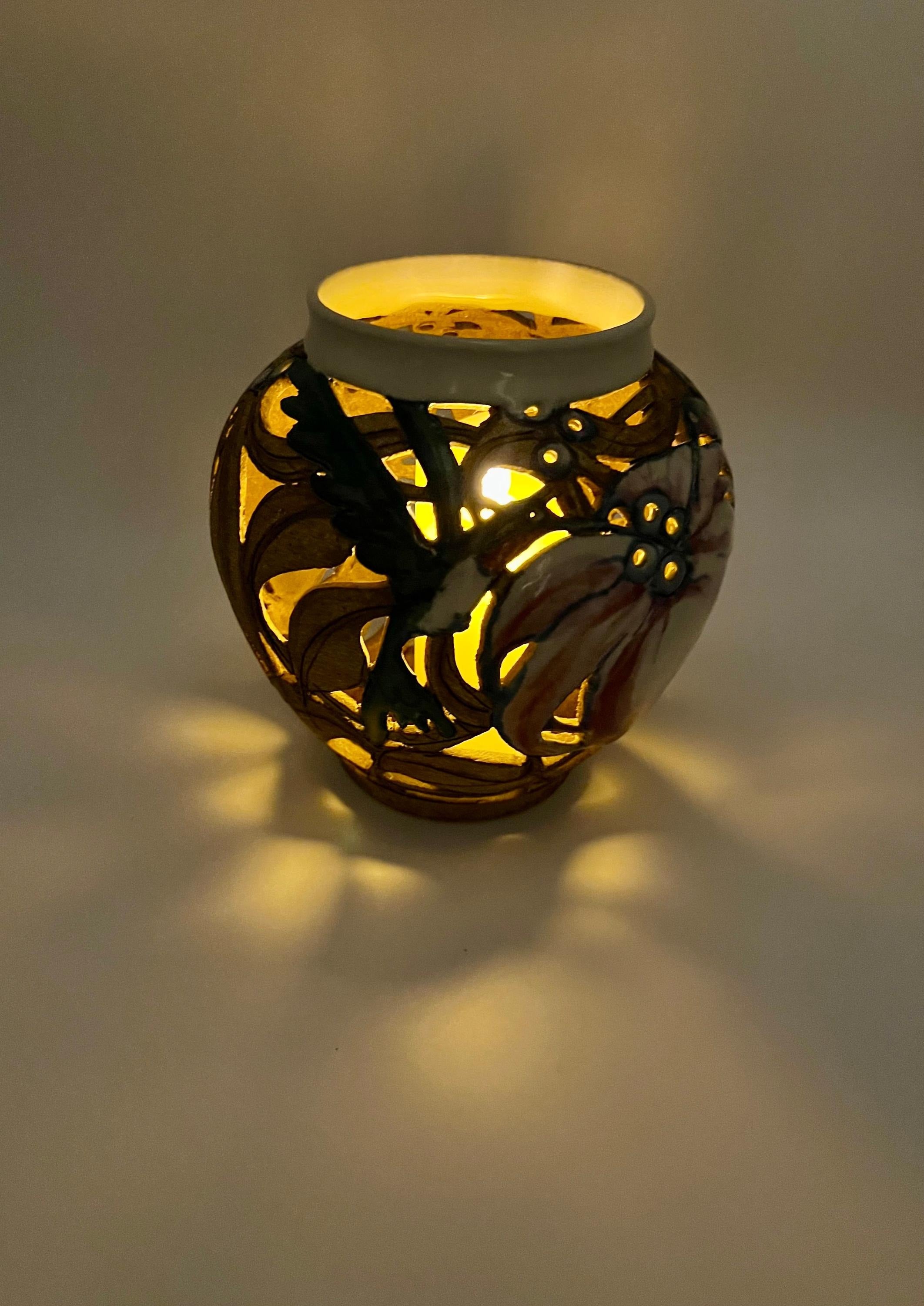 Artist-signed decorative piece featuring a hummingbird motif, usable as a vase or candle lantern.