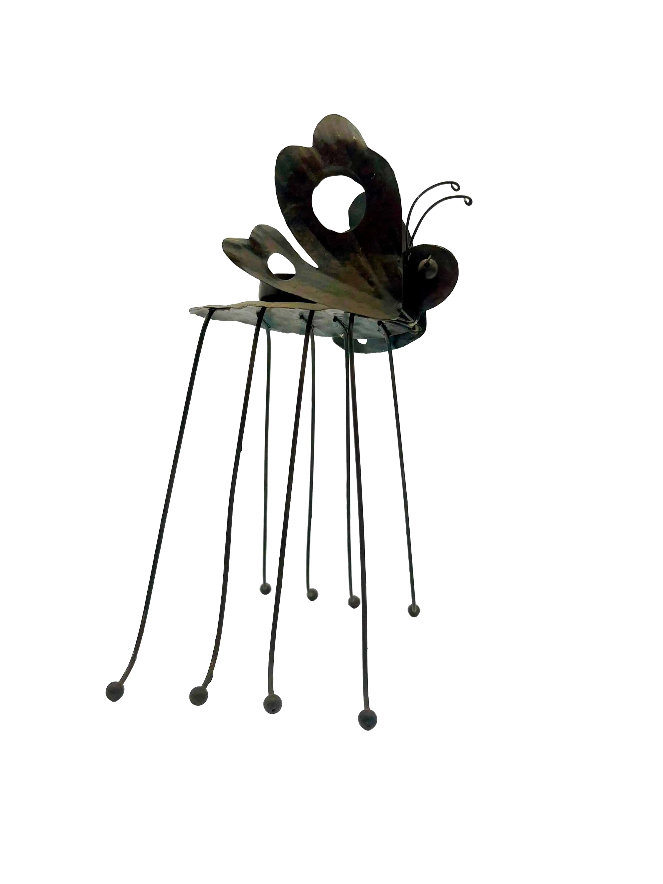 Whimsical vintage metal candle holder shaped like a butterfly with open-work wings.
