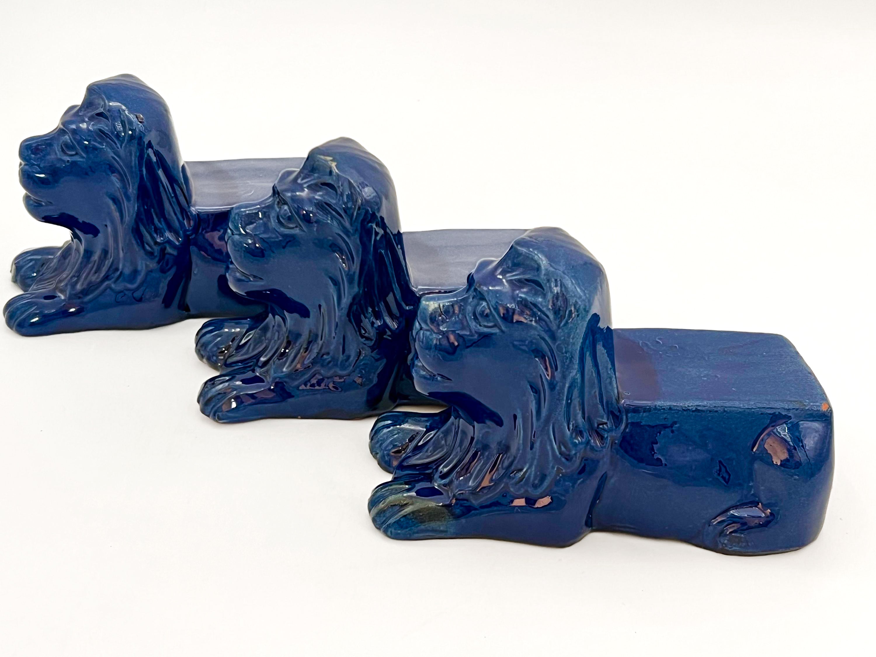 Set of three decorative terra cotta lion sculptures in a unique petroleum blue glaze.