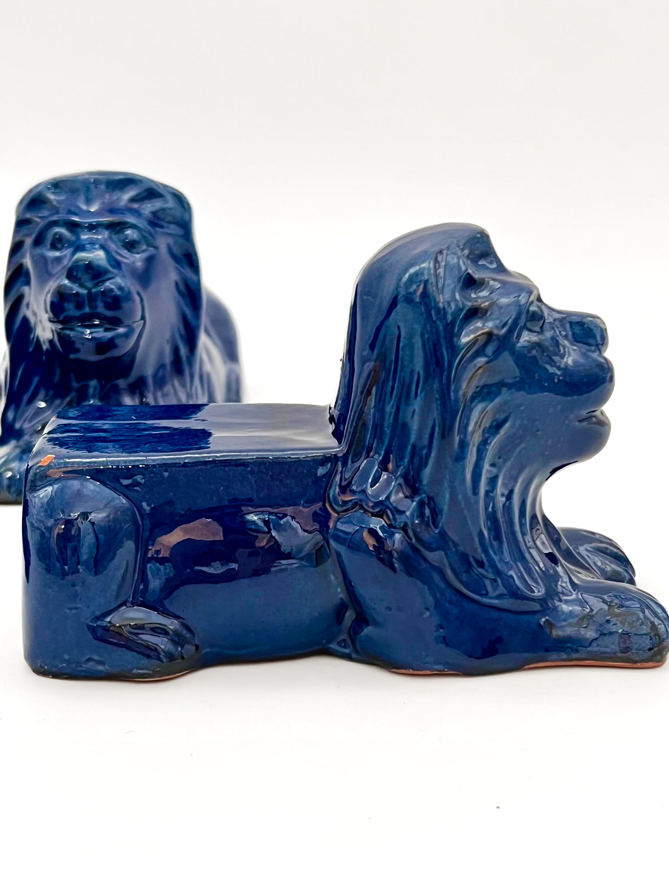 Set of three decorative terra cotta lion sculptures in a unique petroleum blue glaze.