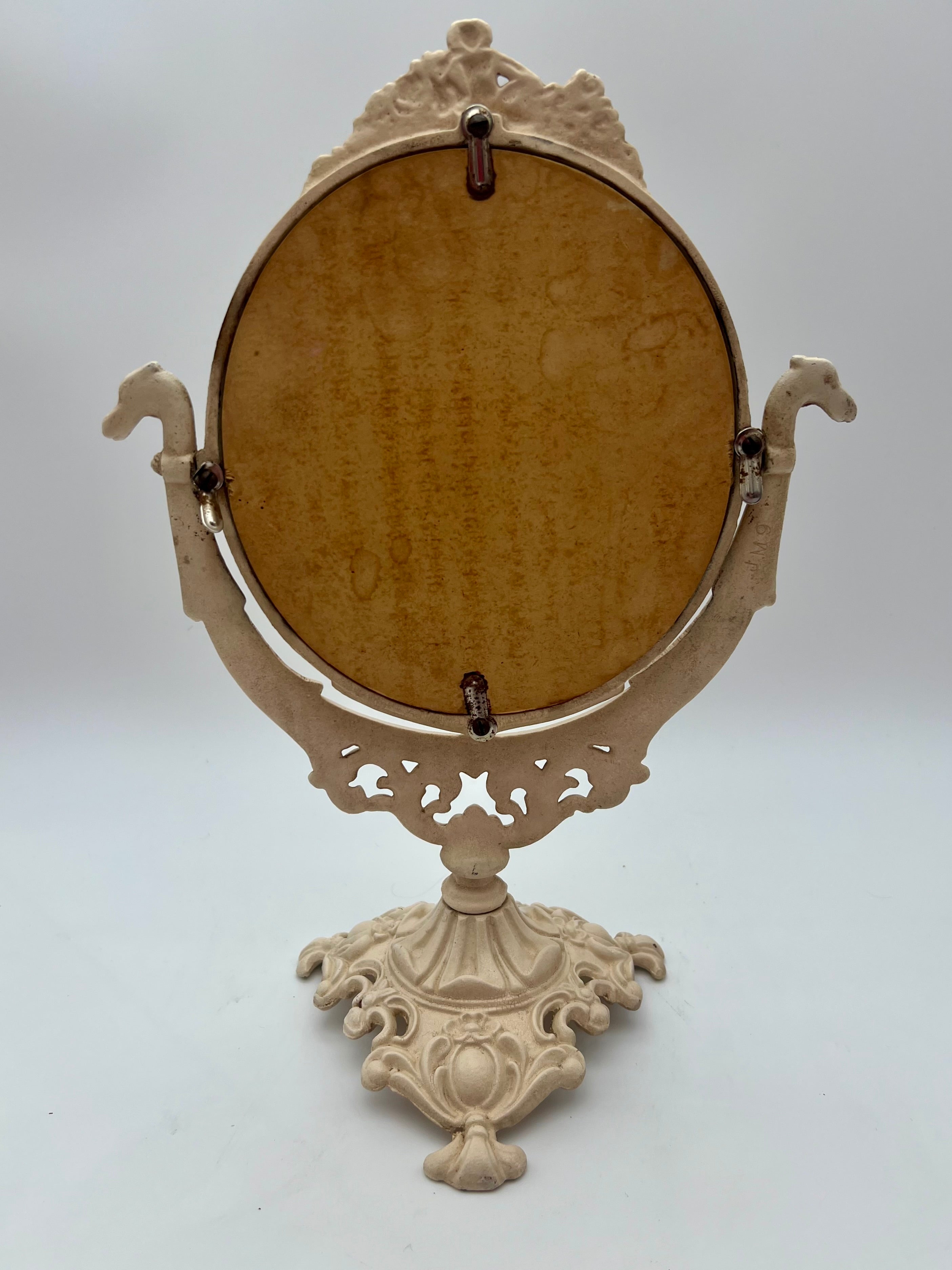 ANTIQUE VANITY TABLE MIRROR WITH DOG HEAD HANDLES & PUTTO CHERUB – ORNATE CAST IRON – 14 ¾ INCH – CIRCA EARLY 1900s
