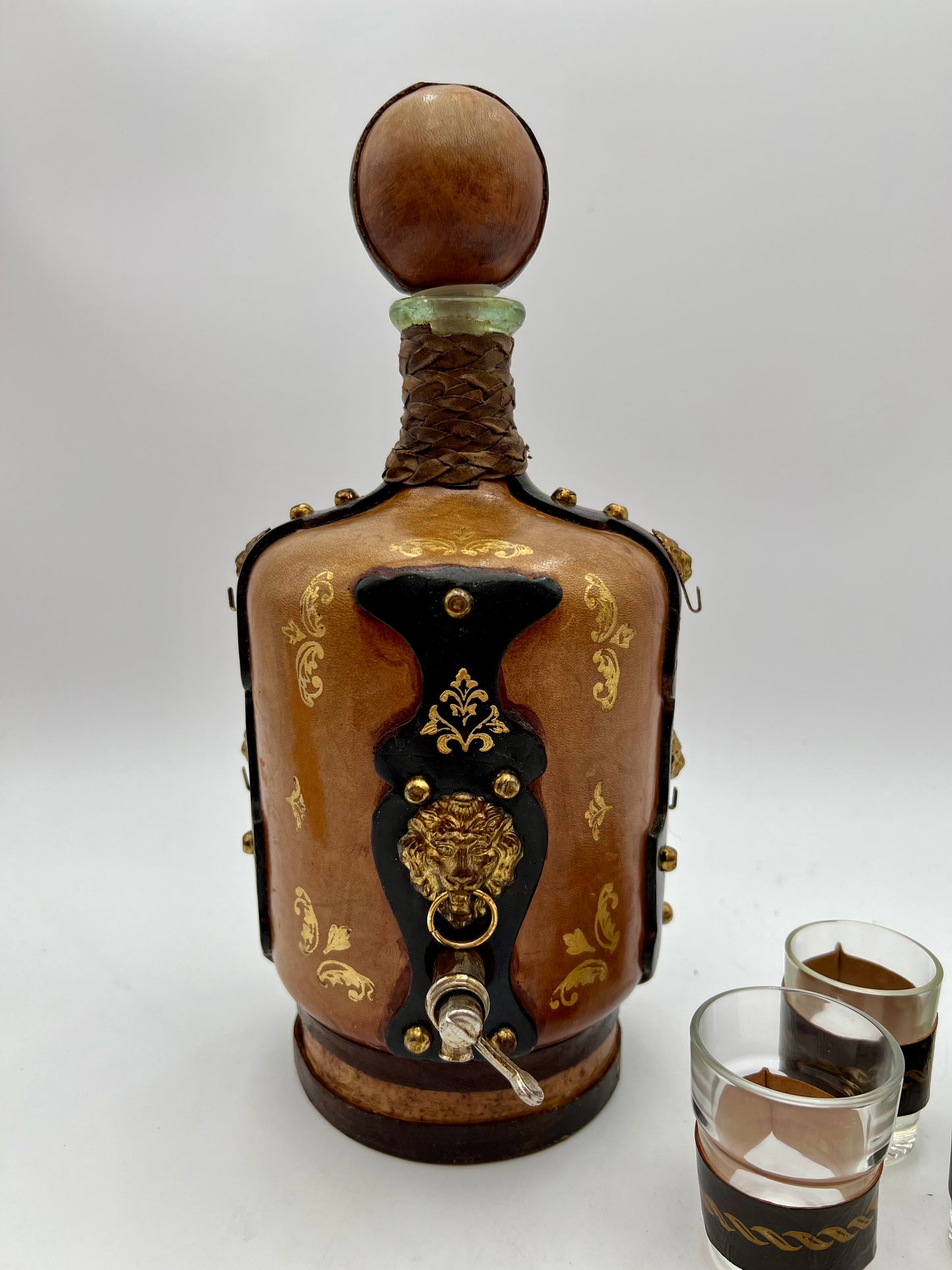 VINTAGE LEATHER WRAPPED WHISKY JUG WITH BRASS TAP AND4 LEATHER WRAPPED SHOT GLASSES