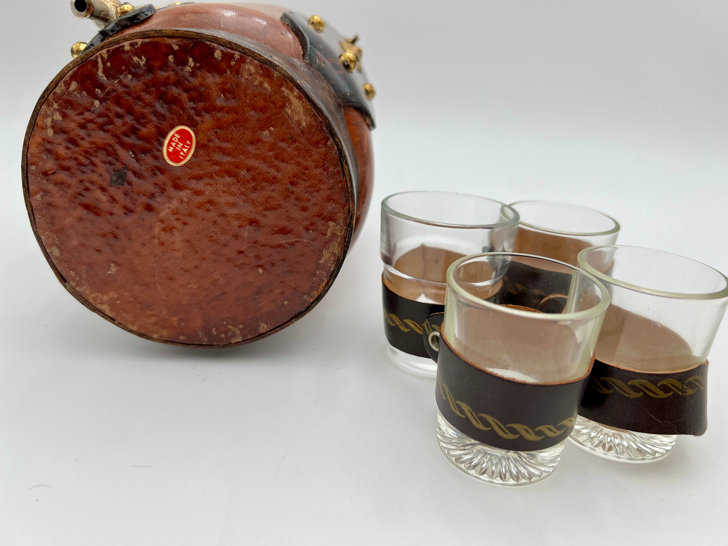 VINTAGE LEATHER WRAPPED WHISKY JUG WITH BRASS TAP AND4 LEATHER WRAPPED SHOT GLASSES