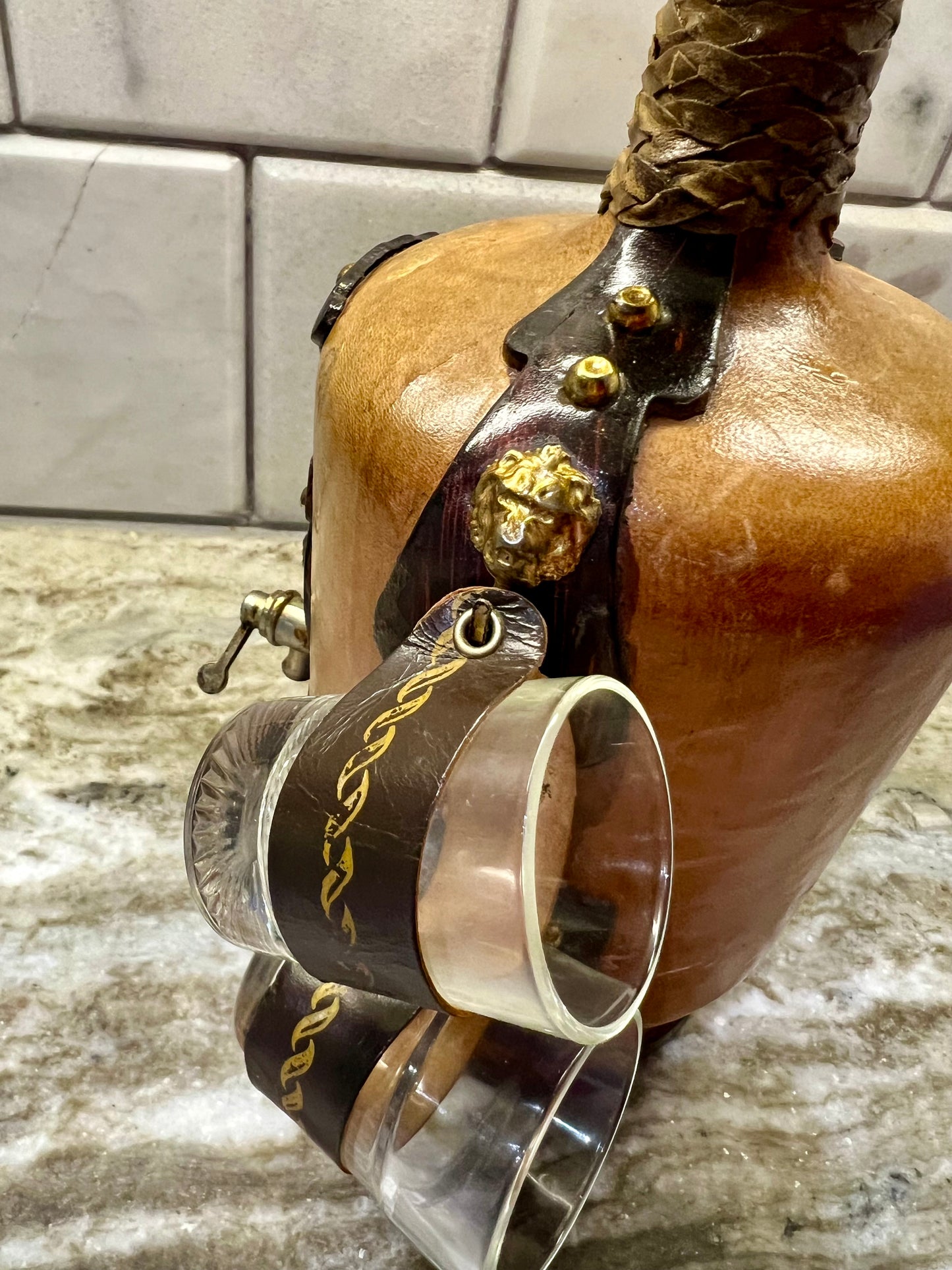 VINTAGE LEATHER WRAPPED WHISKY JUG WITH BRASS TAP AND4 LEATHER WRAPPED SHOT GLASSES