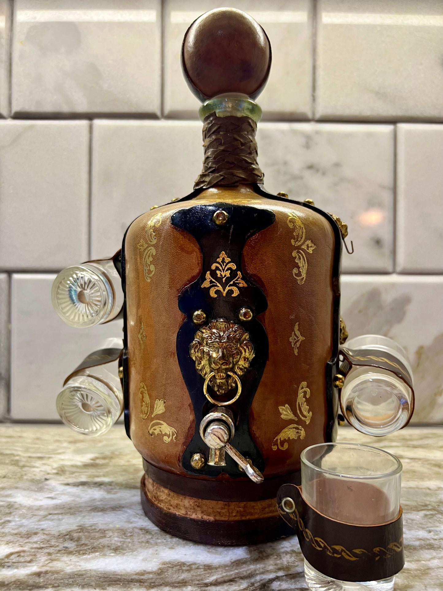 VINTAGE LEATHER WRAPPED WHISKY JUG WITH BRASS TAP AND4 LEATHER WRAPPED SHOT GLASSES