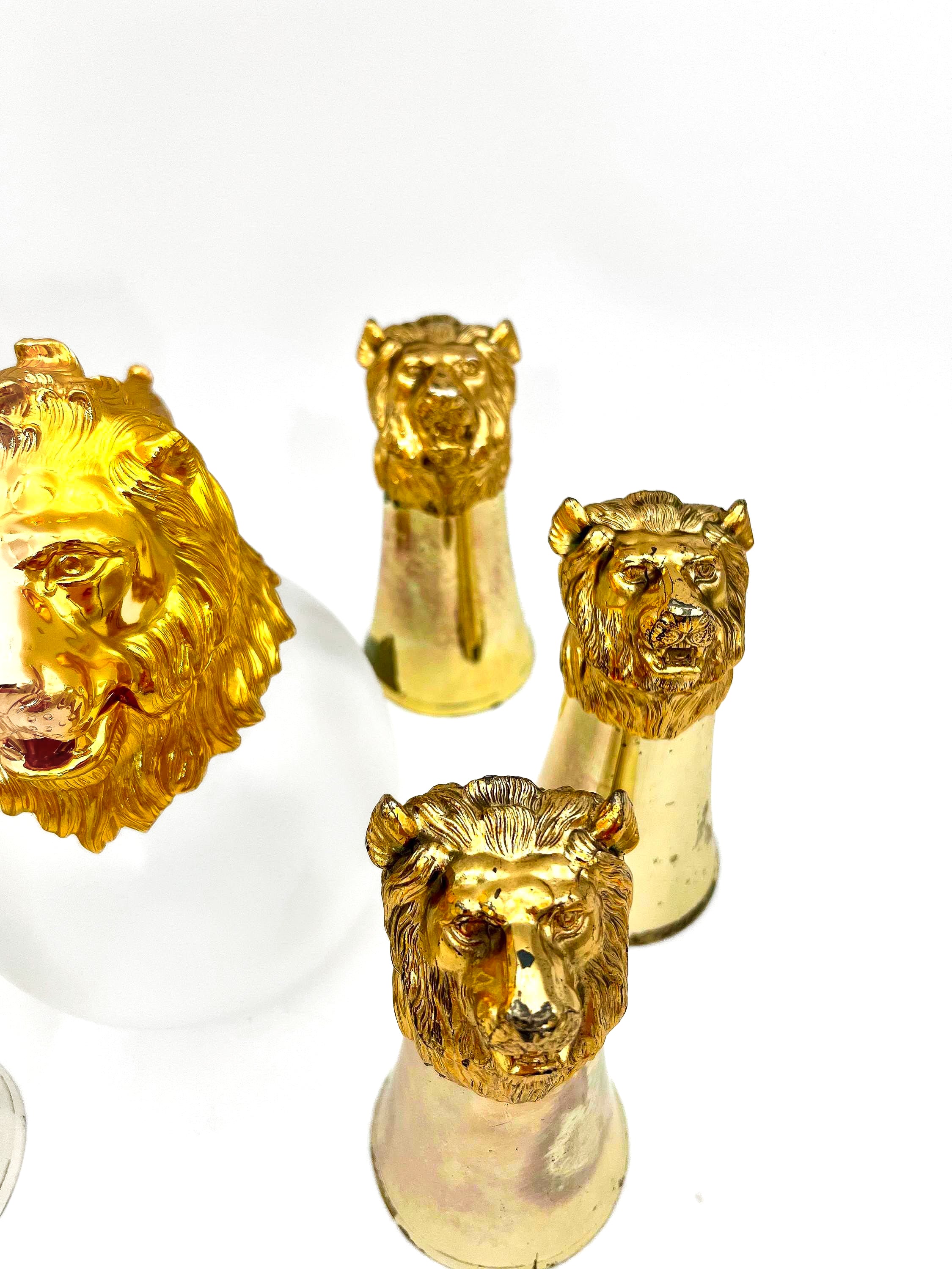 Rare set of 7 Carole Stupell mid-century barware featuring a glass pitcher and stirrup cups with silver-toned lion head bases.