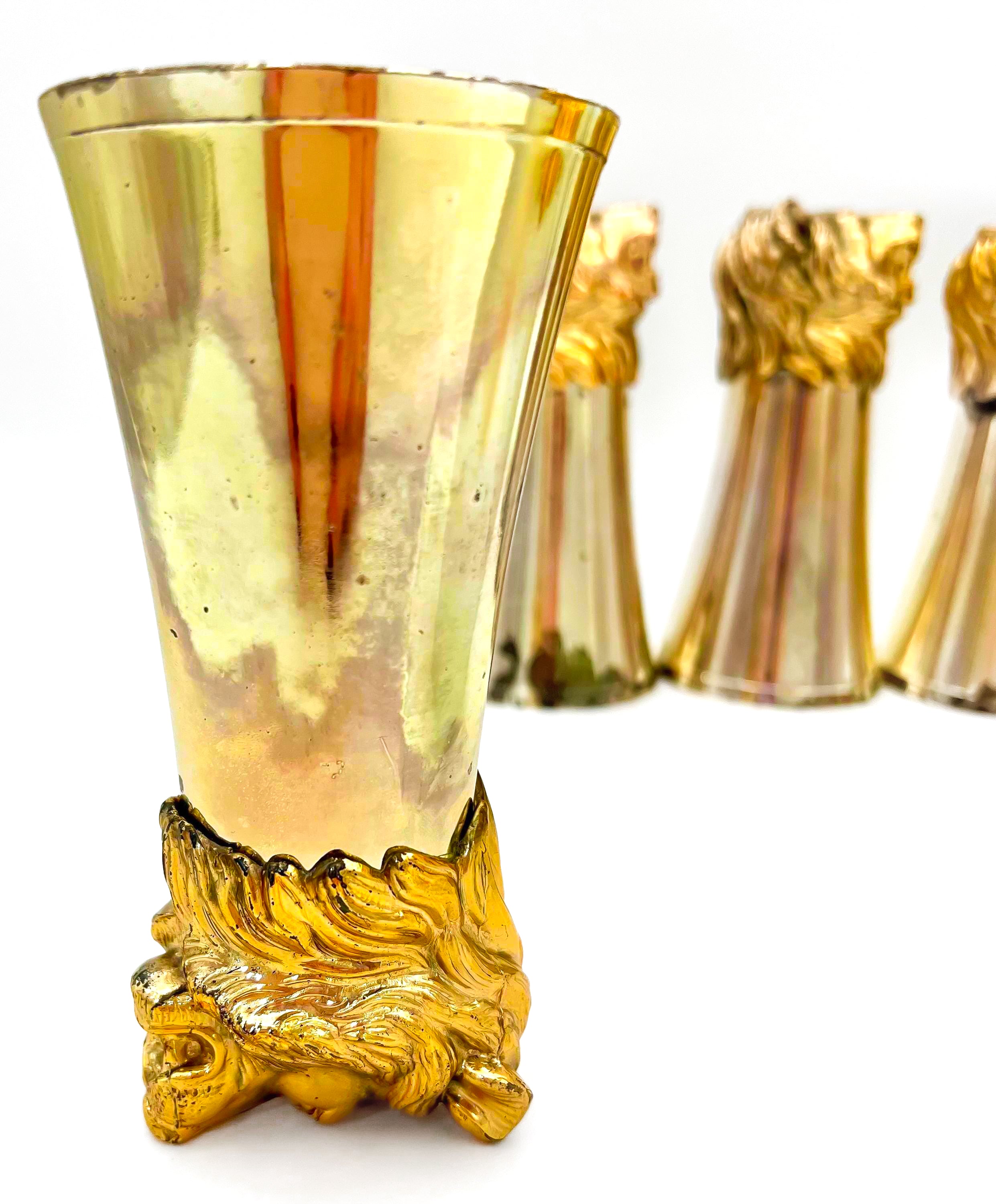 Rare set of 7 Carole Stupell mid-century barware featuring a glass pitcher and stirrup cups with silver-toned lion head bases.