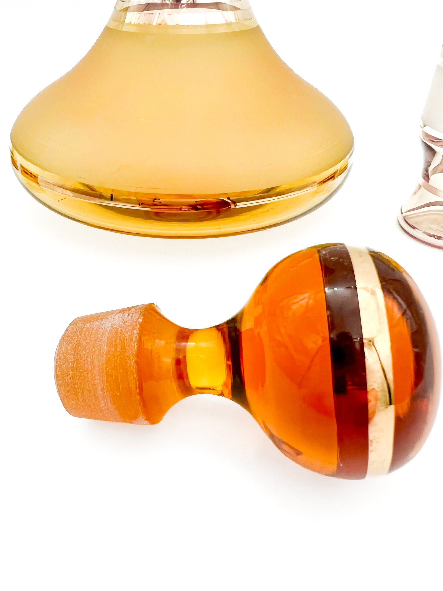 Vintage mid-century cordial set featuring an amber glass decanter with elegant gold filigree accents.