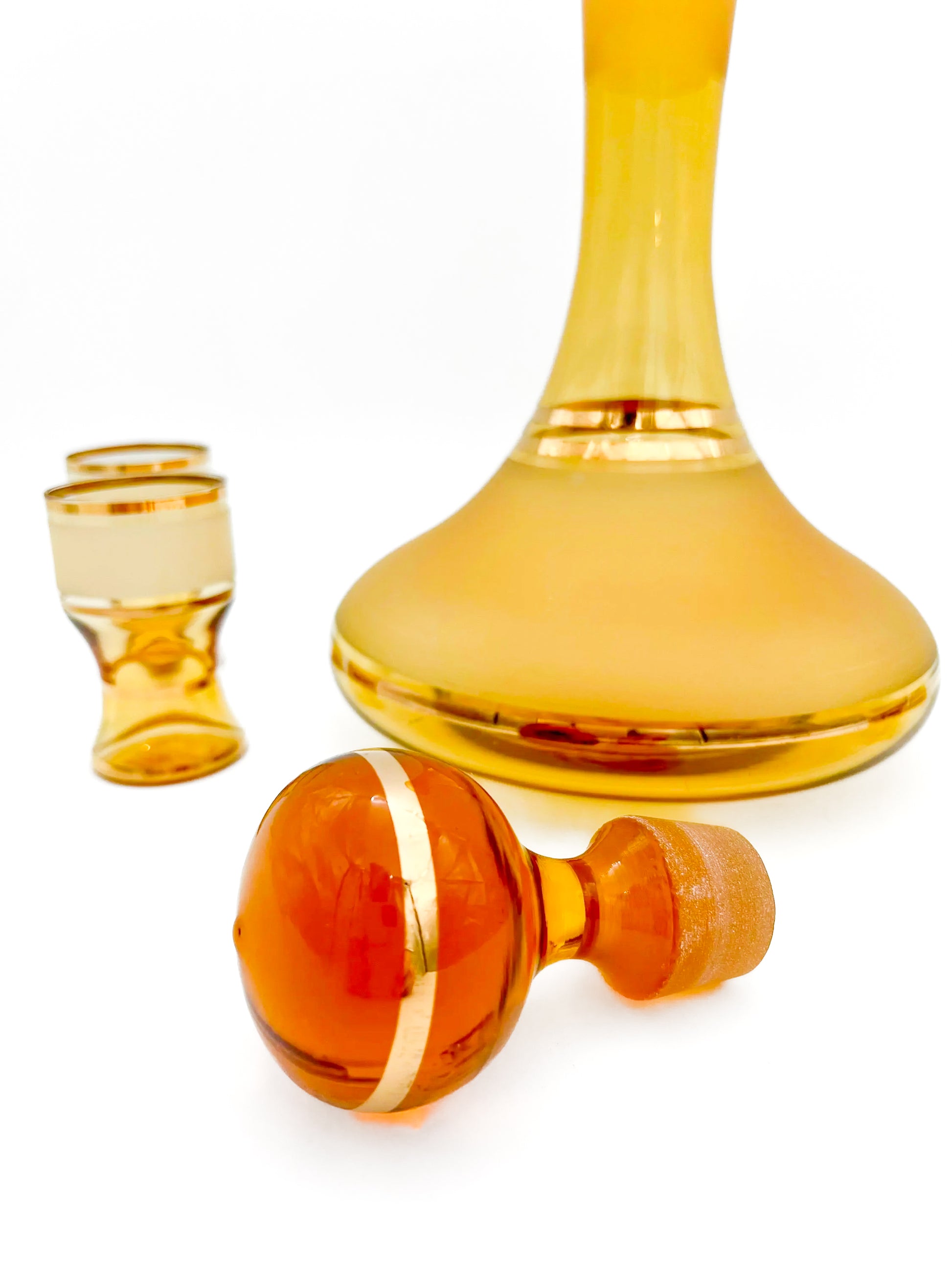 Vintage mid-century cordial set featuring an amber glass decanter with elegant gold filigree accents.