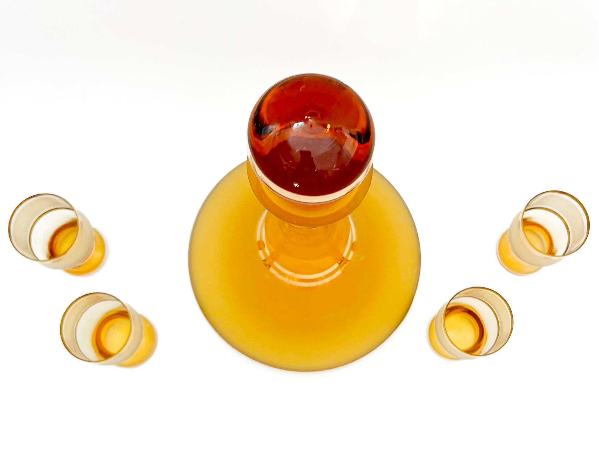 Vintage mid-century cordial set featuring an amber glass decanter with elegant gold filigree accents.