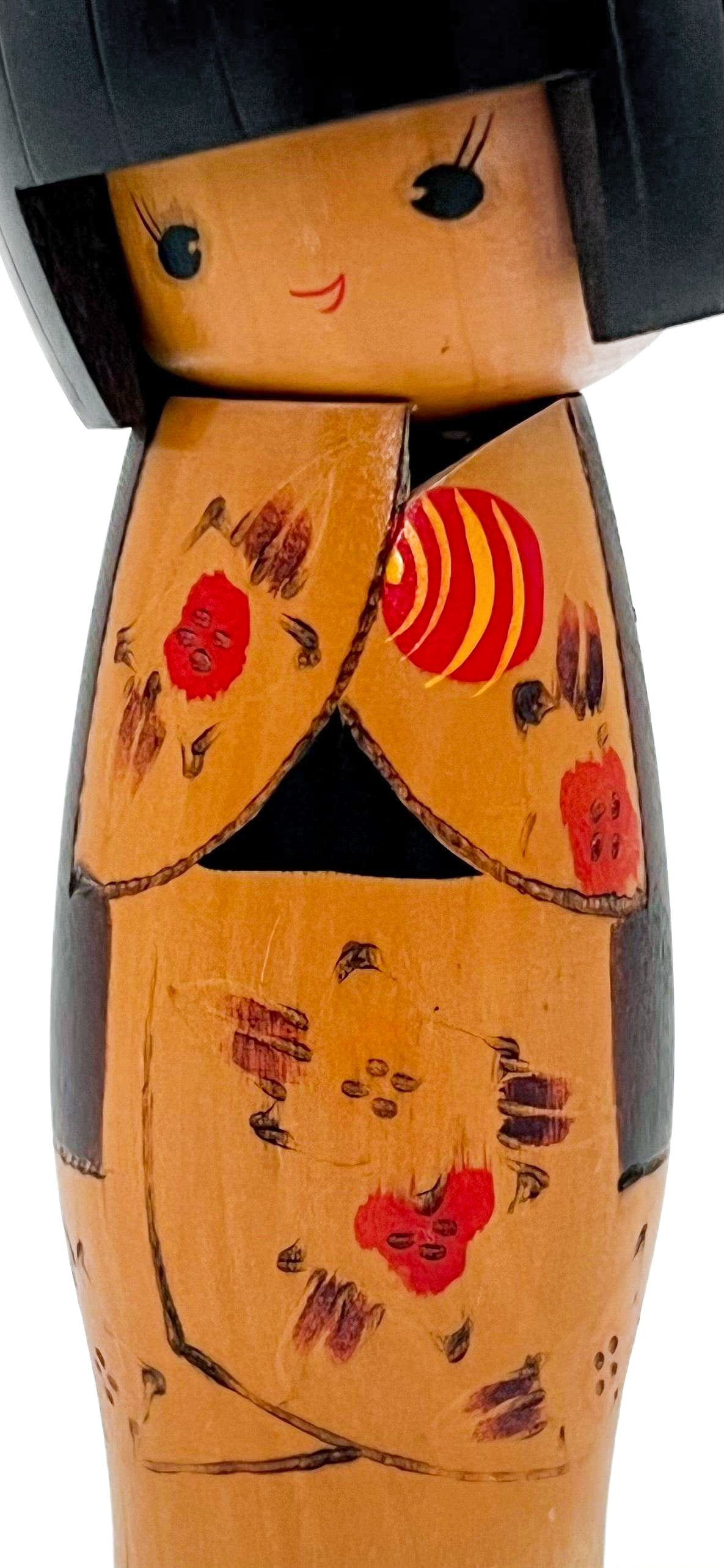 Traditional vintage Japanese Kokeshi doll made of hand-painted wood with floral accents.