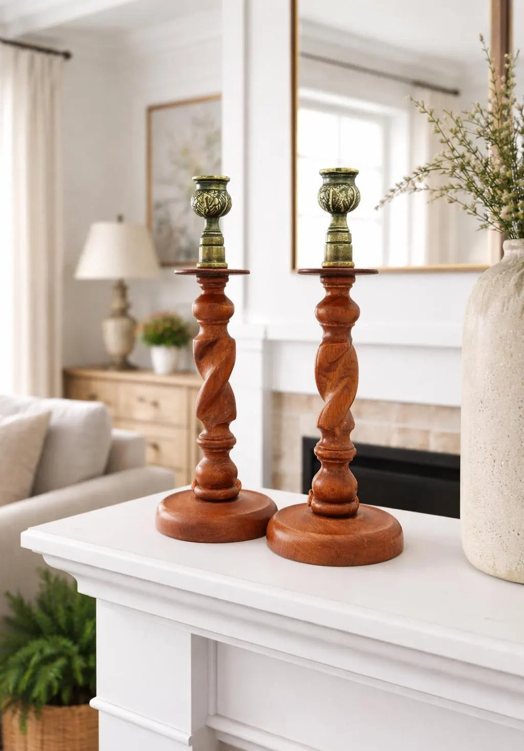 Antique English wooden barley twist candlesticks topped with aged brass thistle-shaped cups.