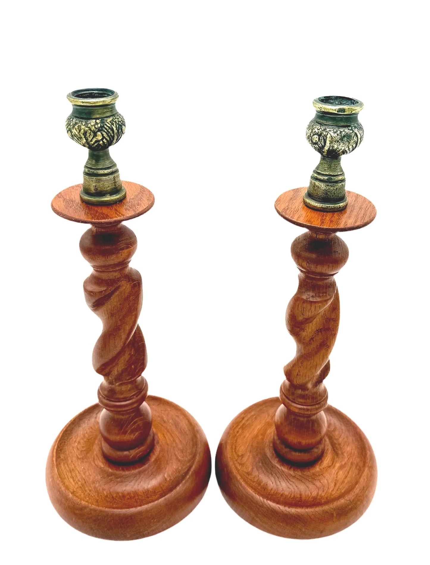 Antique English wooden barley twist candlesticks topped with aged brass thistle-shaped cups.