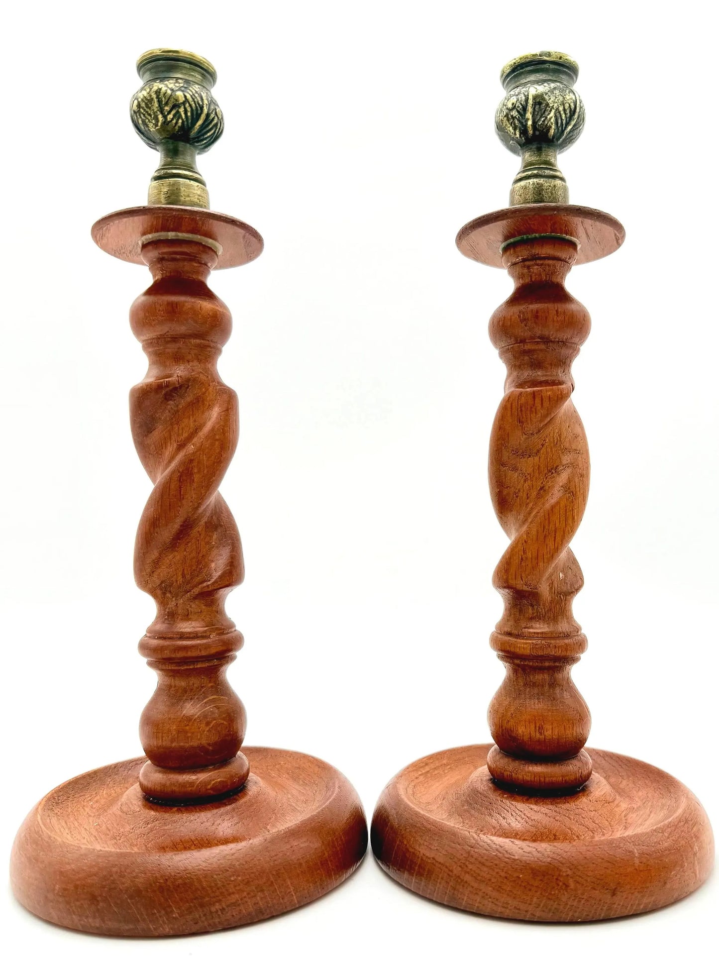 Antique English wooden barley twist candlesticks topped with aged brass thistle-shaped cups.