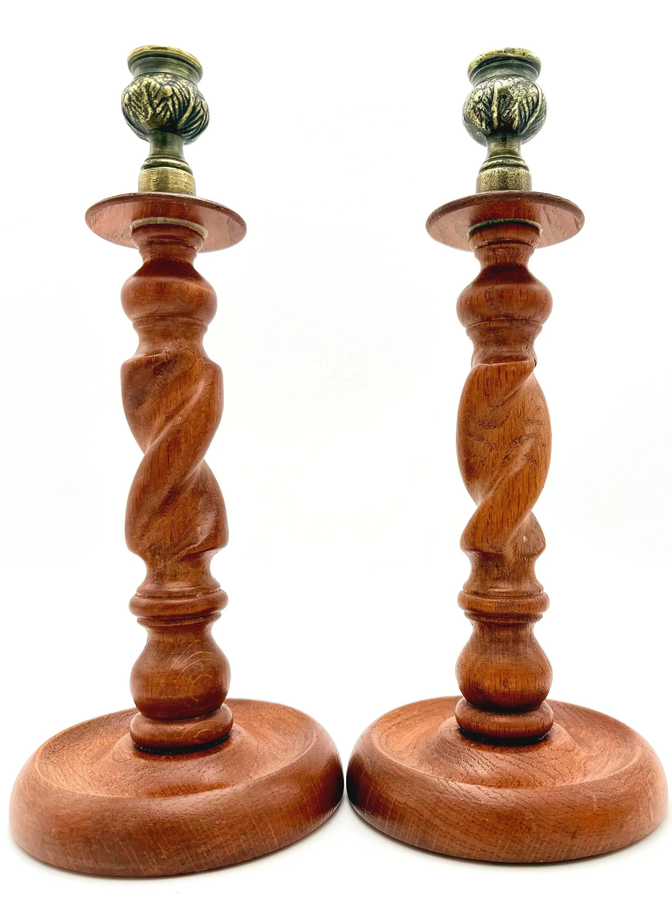Antique English wooden barley twist candlesticks topped with aged brass thistle-shaped cups.