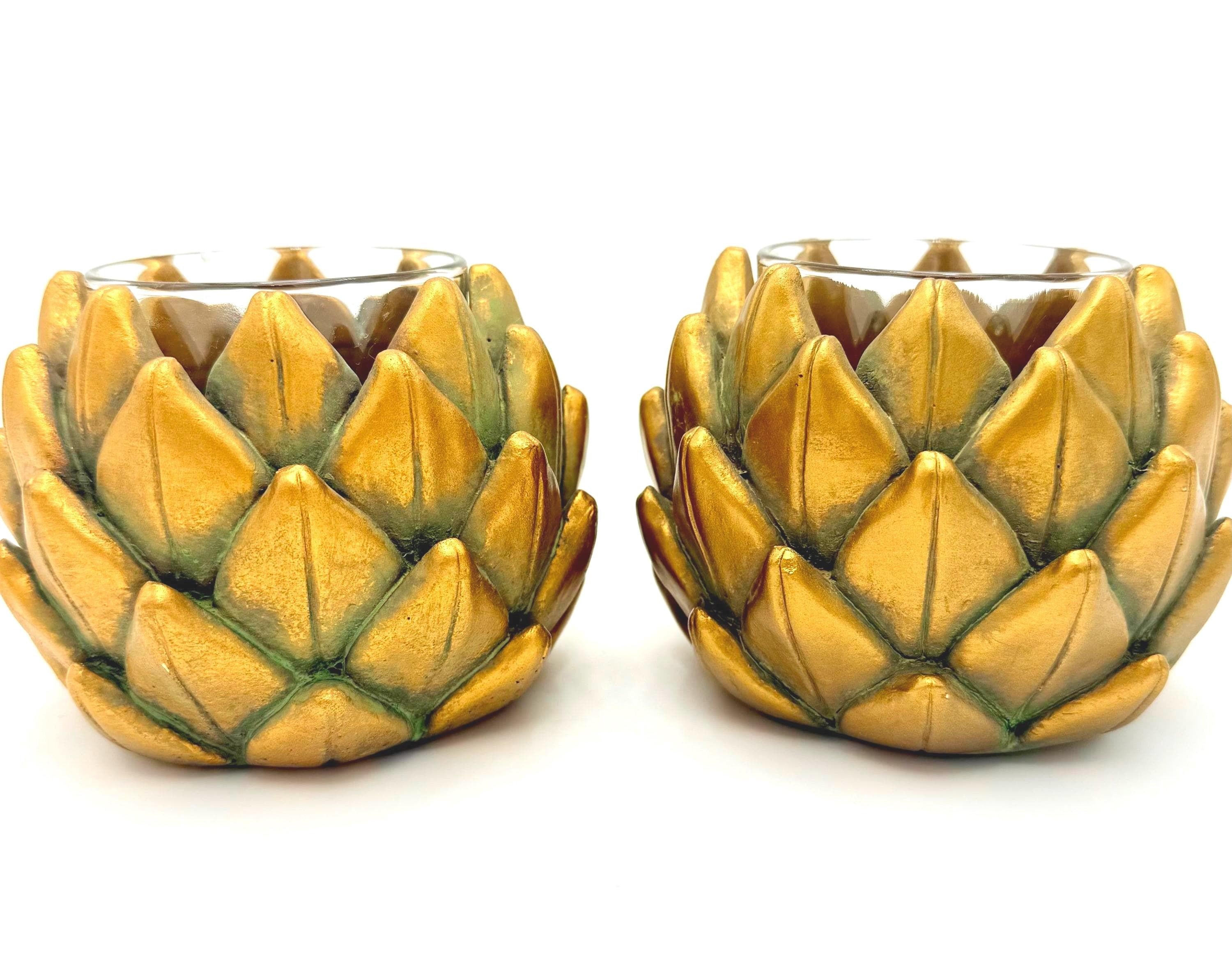 Pair of heavy vintage votive holders shaped like golden artichokes with a metallic finish.