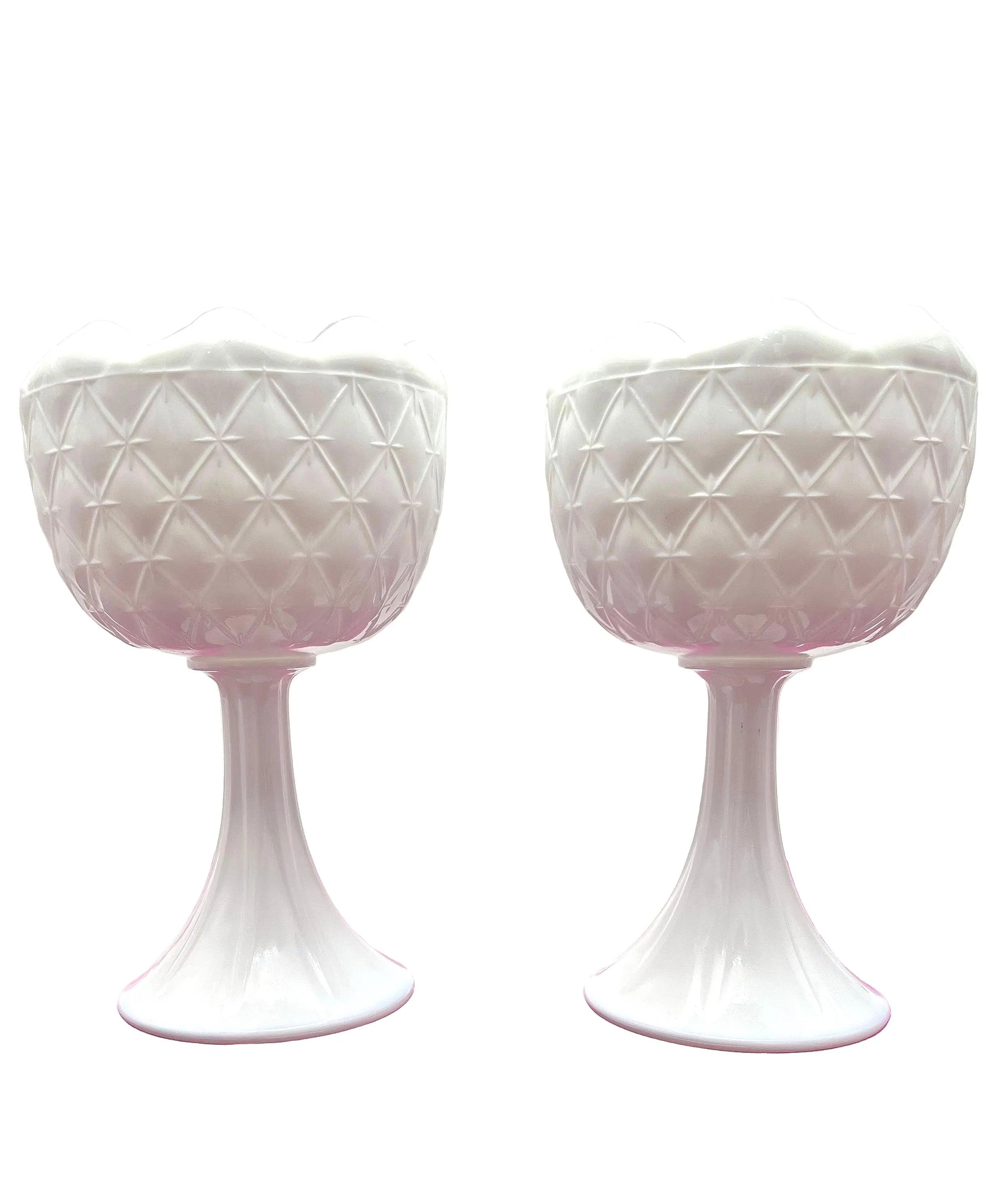 A curated duo of vintage milk glass candle holders in varying heights and classic patterns.