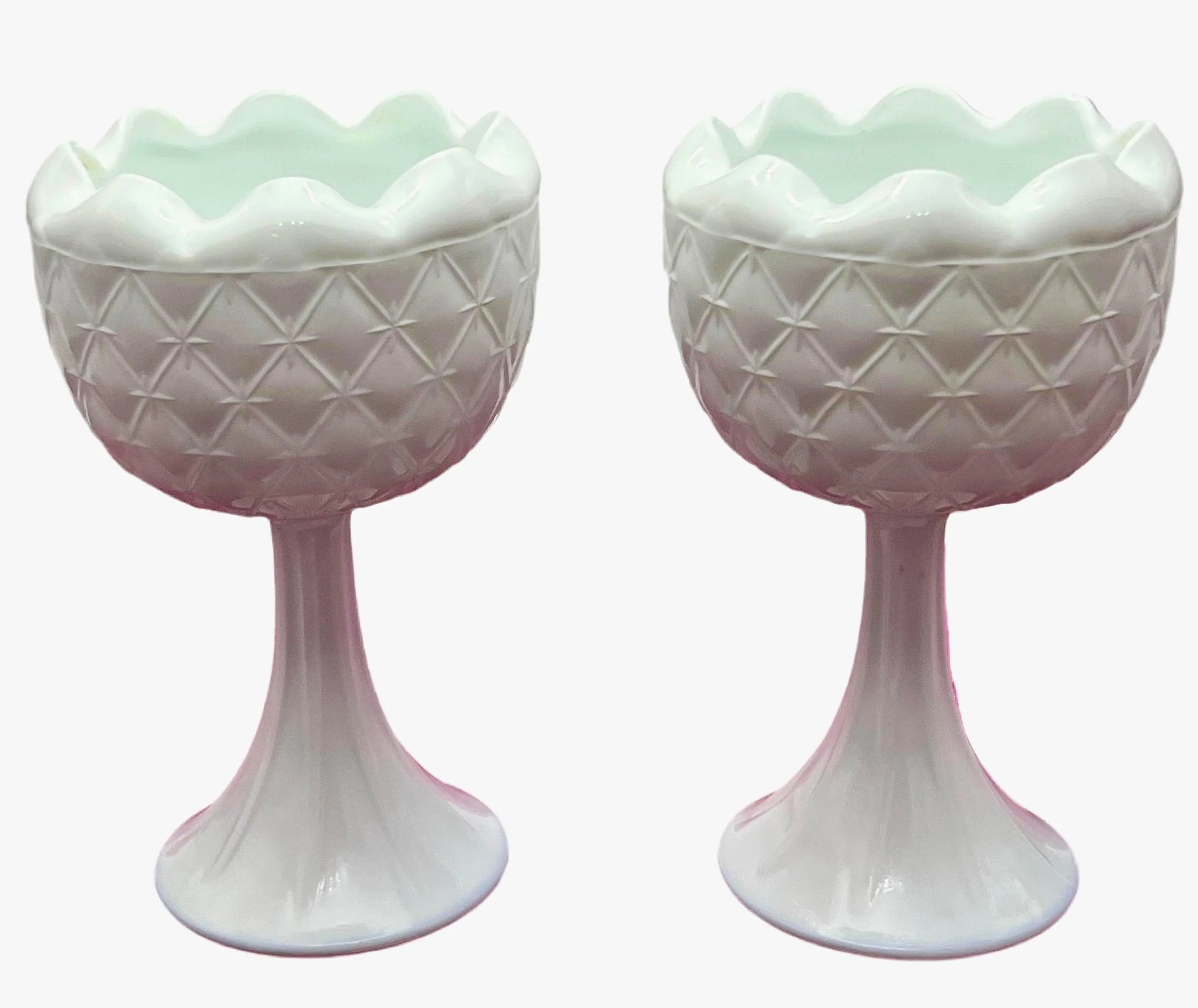 A curated duo of vintage milk glass candle holders in varying heights and classic patterns.
