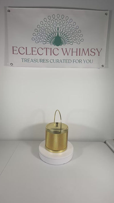 Glamorous 1960s Italian Hollywood Regency ice bucket with a reflective gold finish and matching lid.