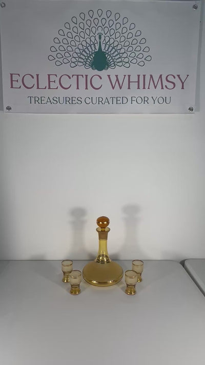 Vintage mid-century cordial set featuring an amber glass decanter with elegant gold filigree accents.