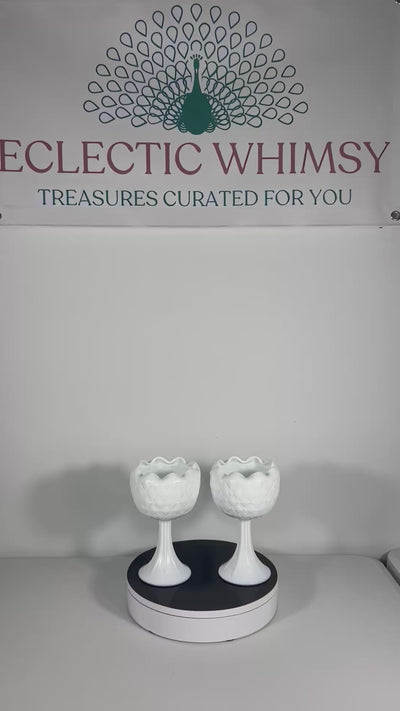 A curated duo of vintage milk glass candle holders in varying heights and classic patterns.