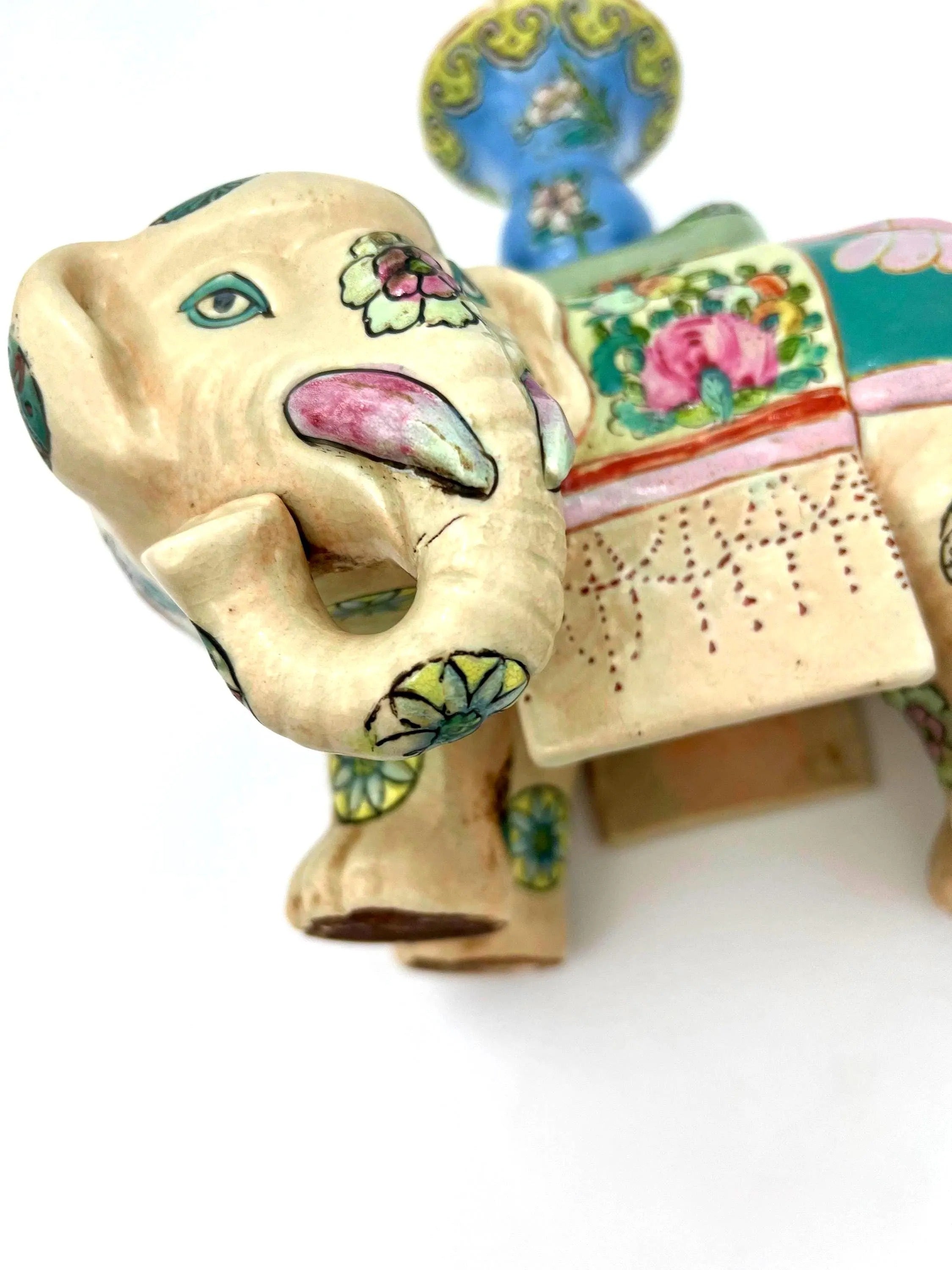 Hand-painted antique Chinese porcelain elephant candleholder with an ornate saddle and floral motifs.