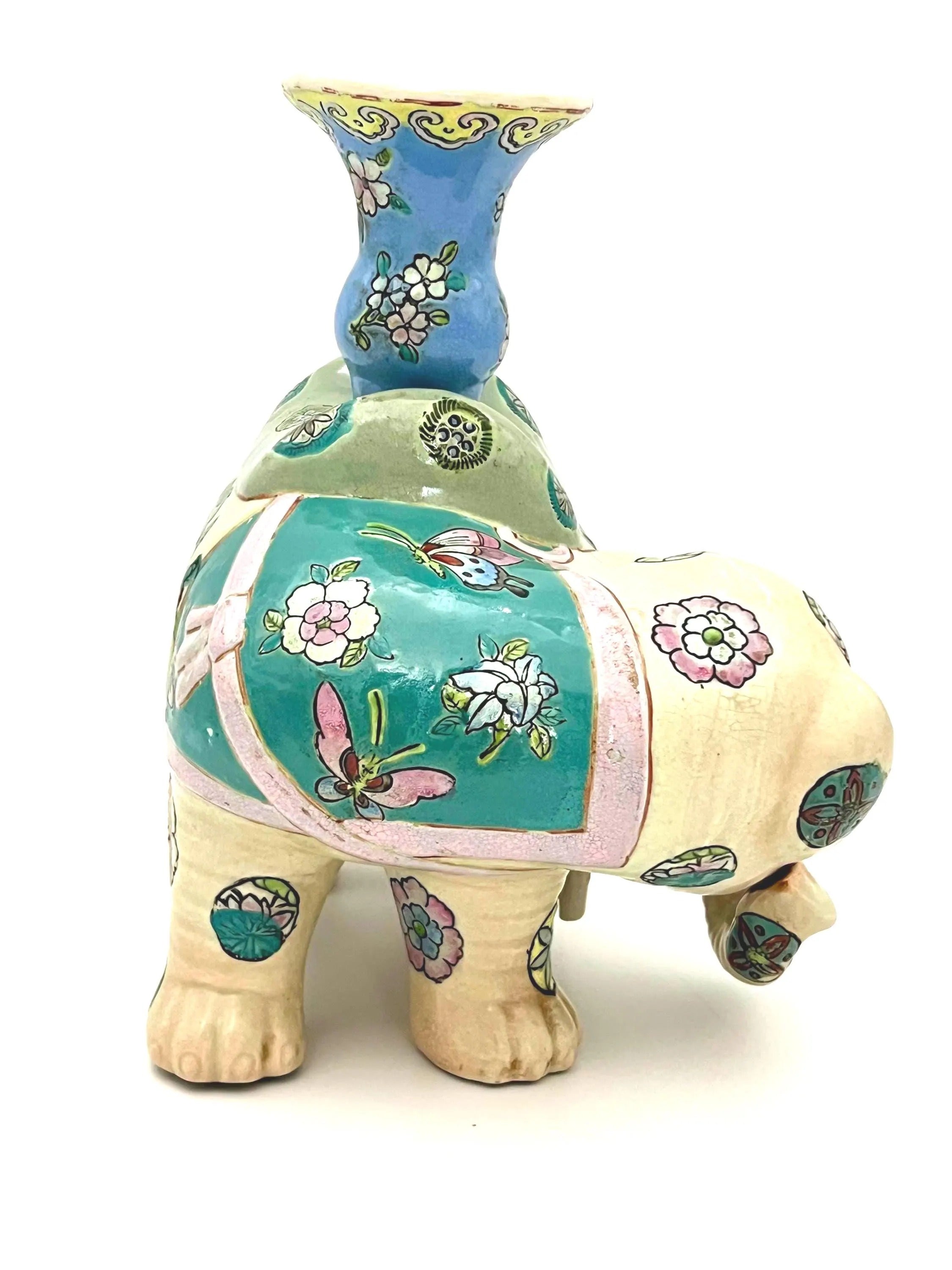 Hand-painted antique Chinese porcelain elephant candleholder with an ornate saddle and floral motifs.