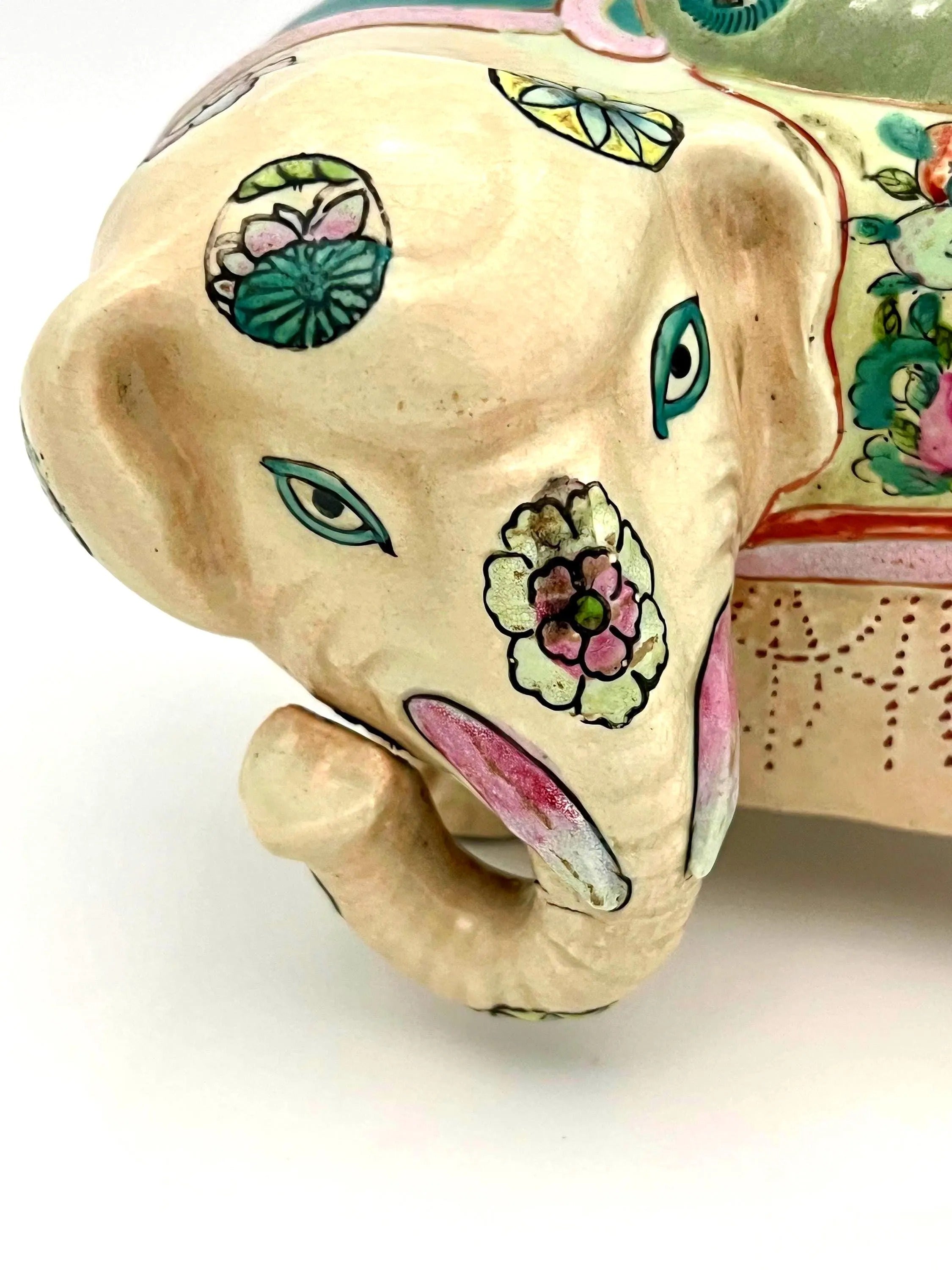 Hand-painted antique Chinese porcelain elephant candleholder with an ornate saddle and floral motifs.
