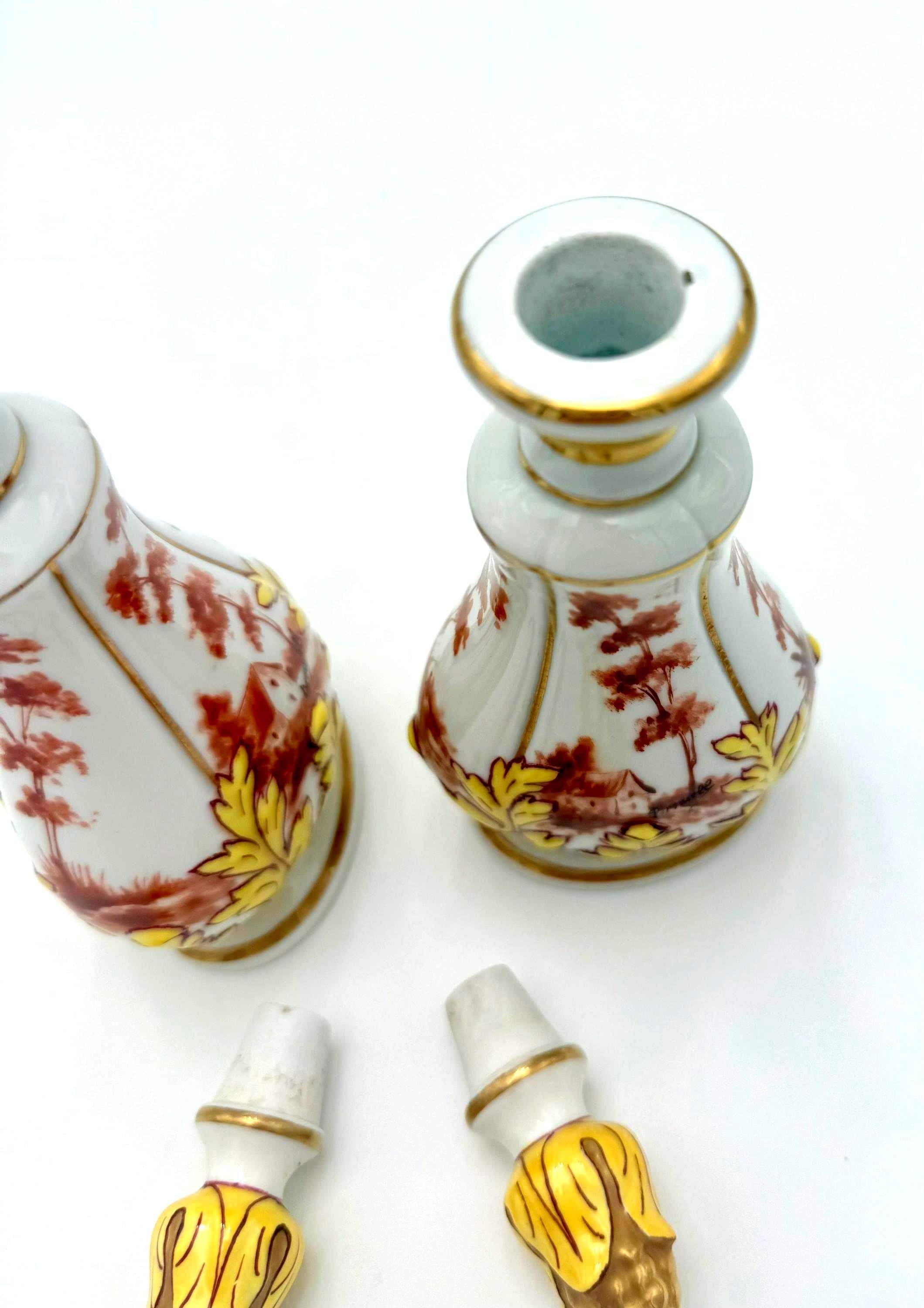 Pair of 19th-century French porcelain cologne bottles with intricate hand-painted Victorian scenes.