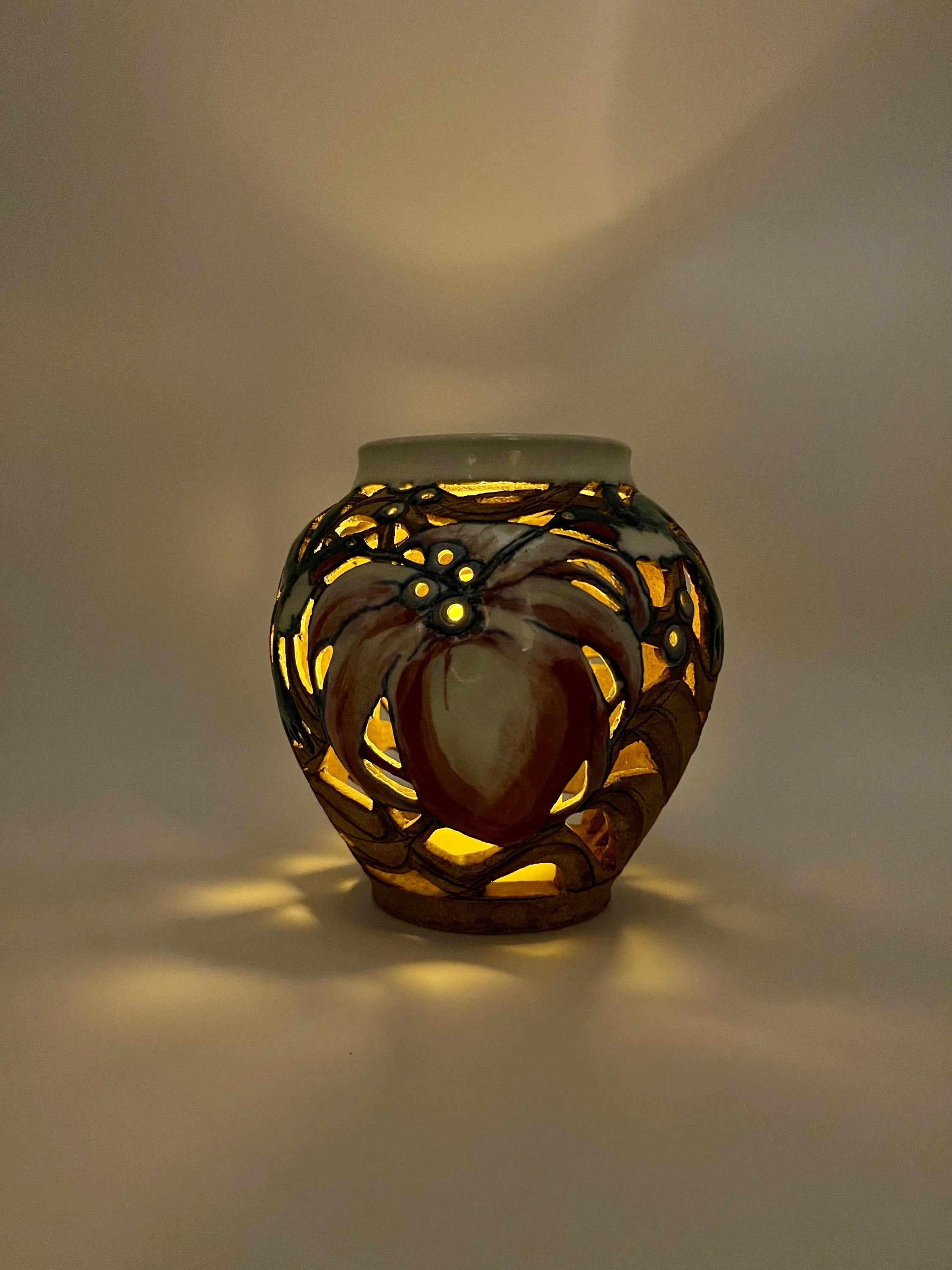 Artist-signed decorative piece featuring a hummingbird motif, usable as a vase or candle lantern.