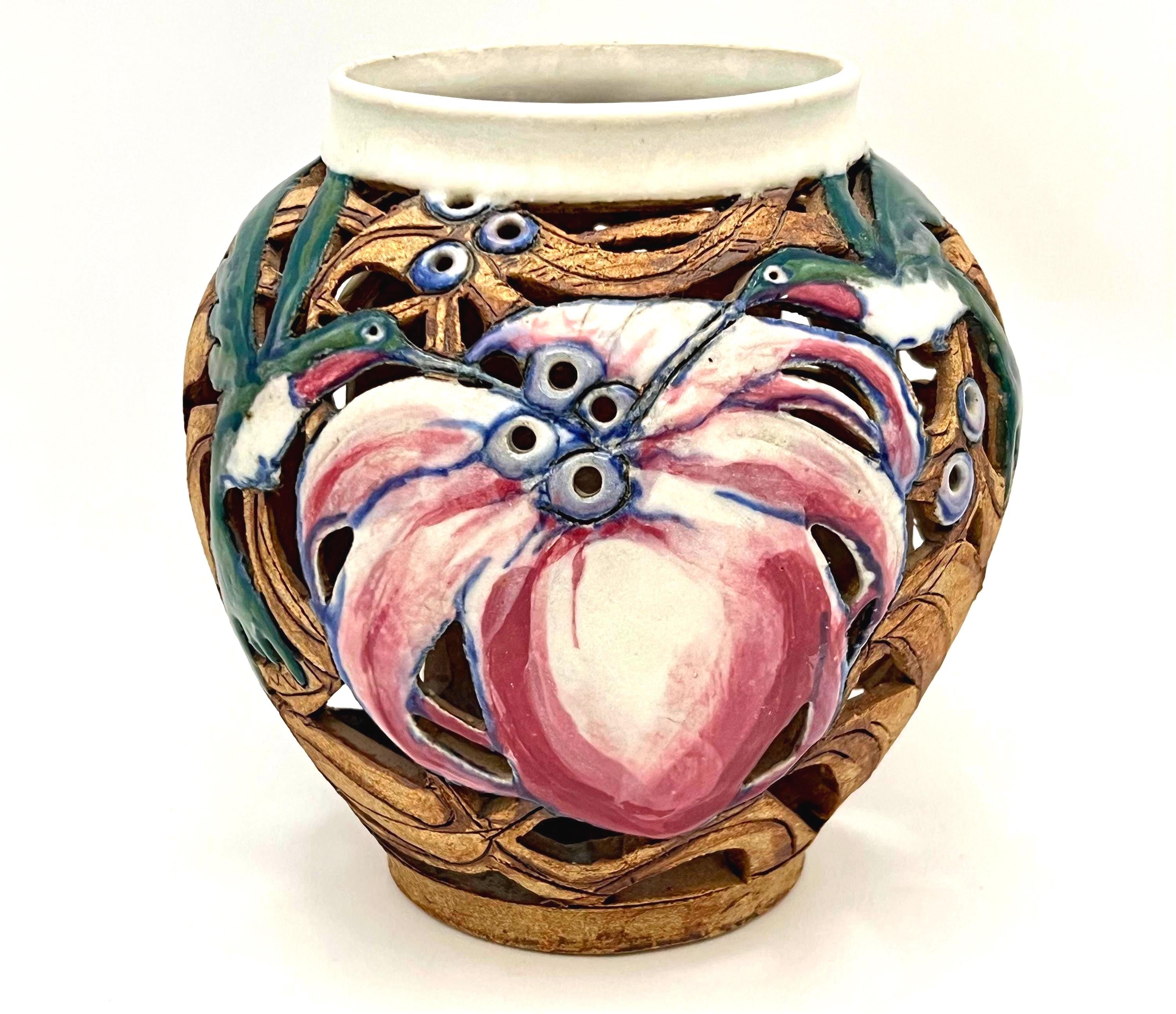 Artist-signed decorative piece featuring a hummingbird motif, usable as a vase or candle lantern.