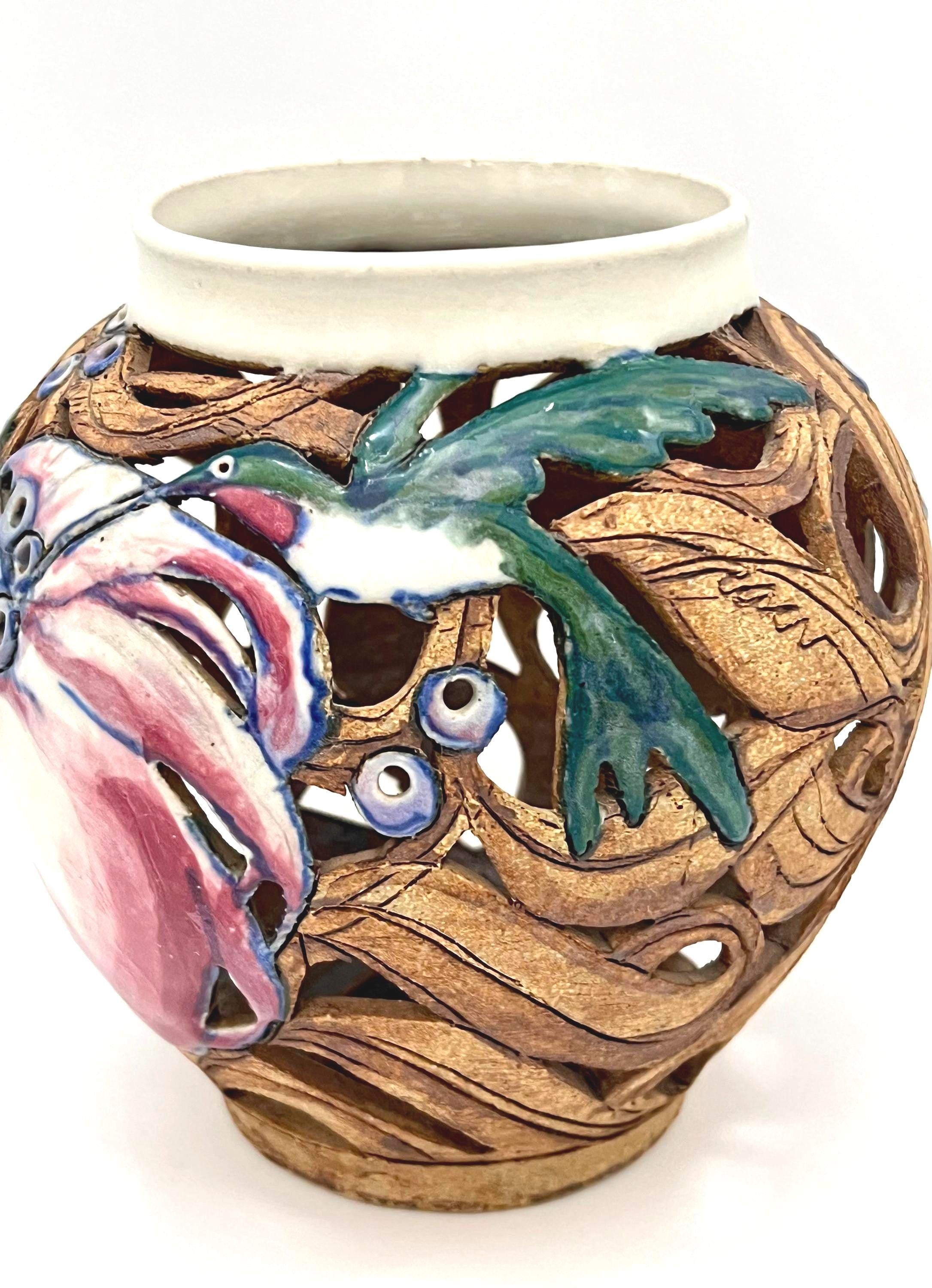 Artist-signed decorative piece featuring a hummingbird motif, usable as a vase or candle lantern.