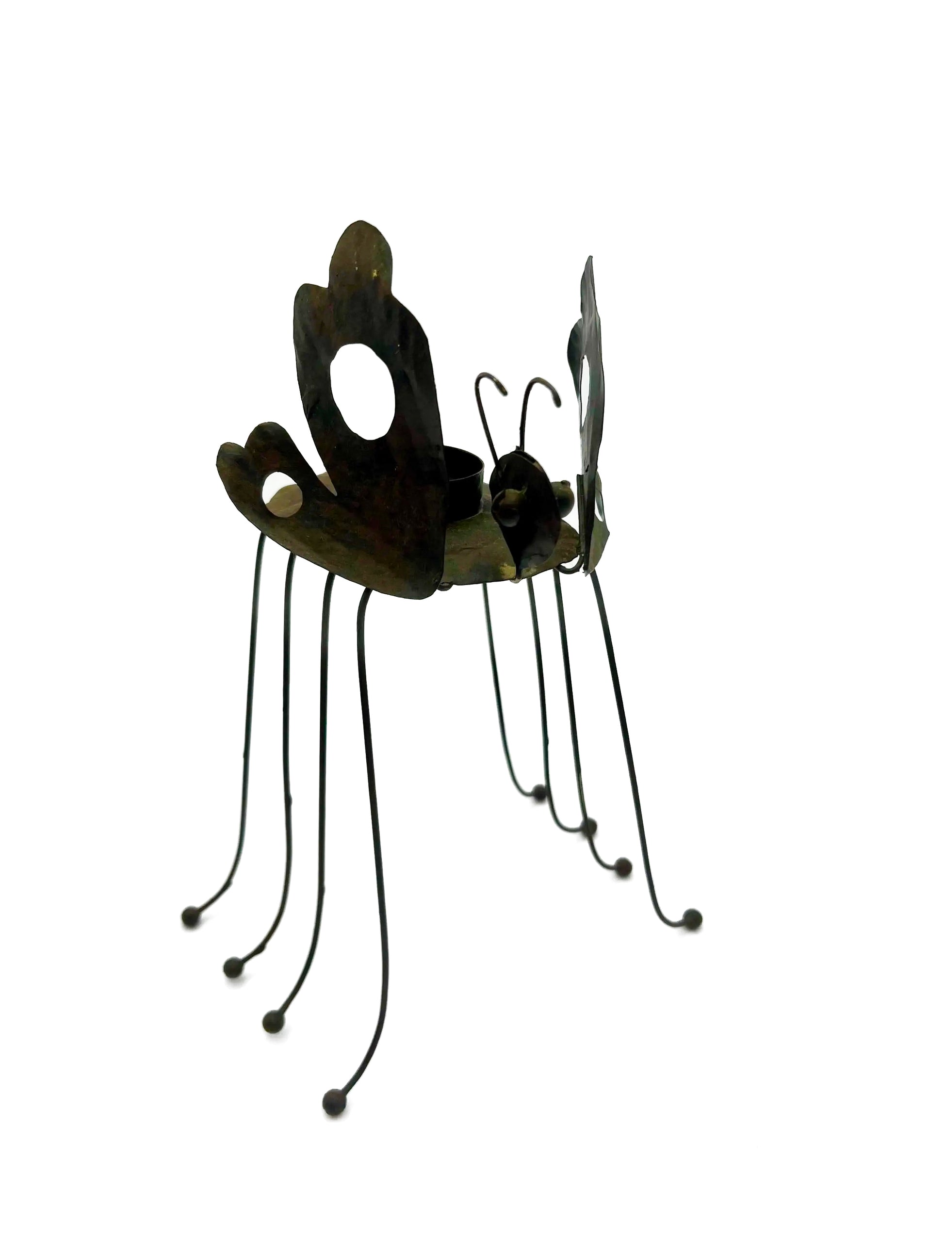 Whimsical vintage metal candle holder shaped like a butterfly with open-work wings.