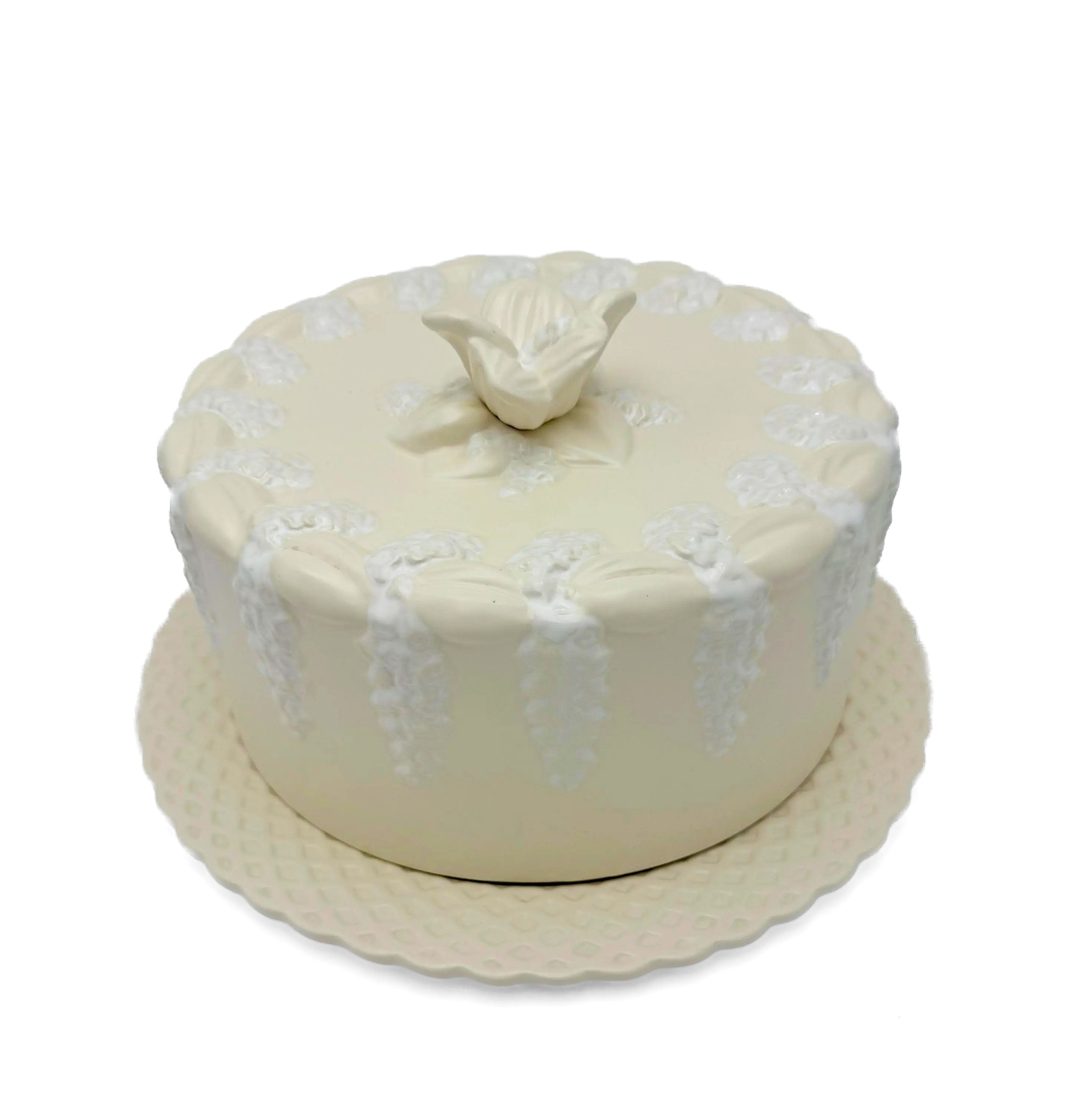 Large Portuguese earthenware dome and matching plate with a cream-white floral relief design.