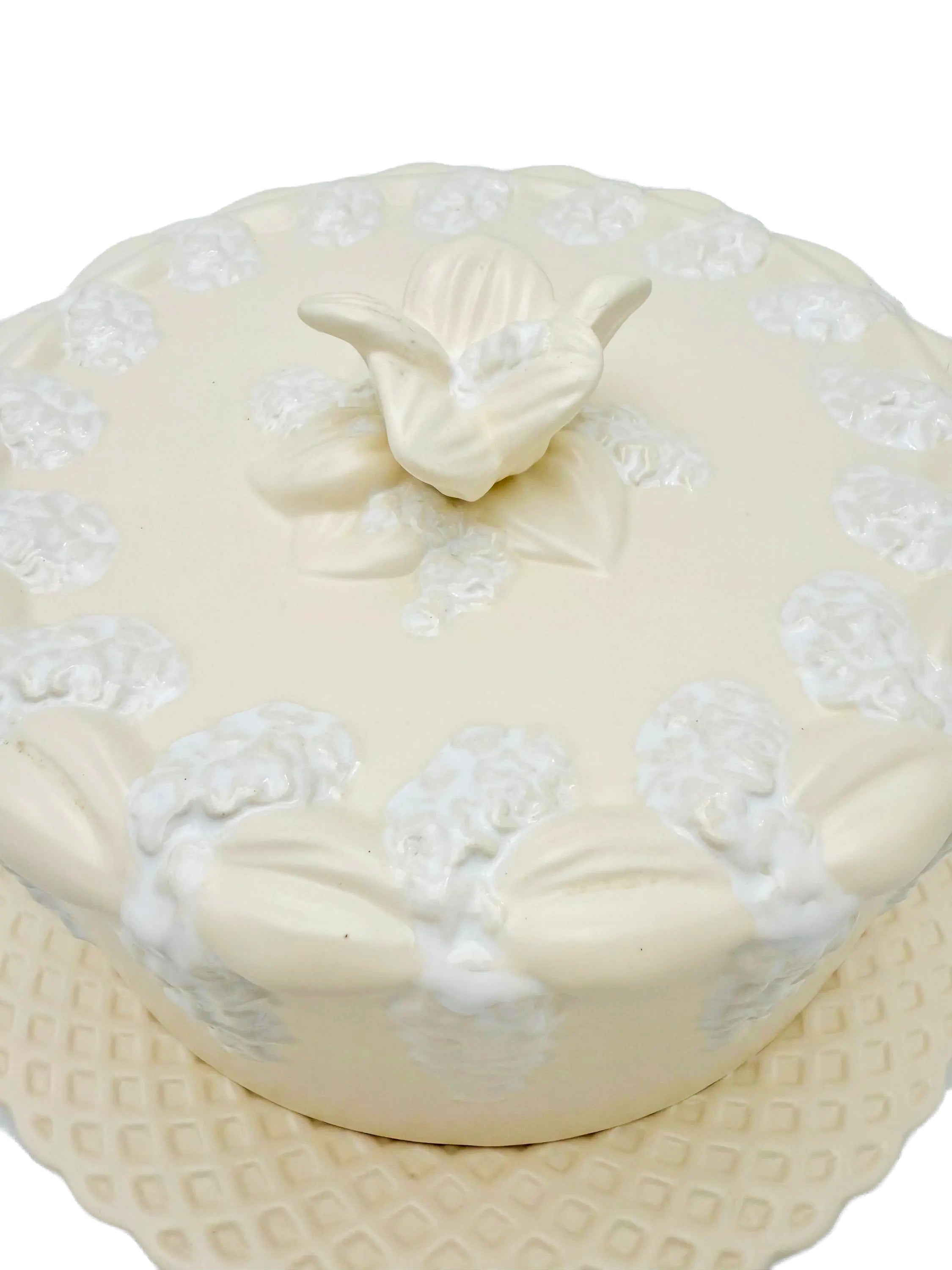 Large Portuguese earthenware dome and matching plate with a cream-white floral relief design.