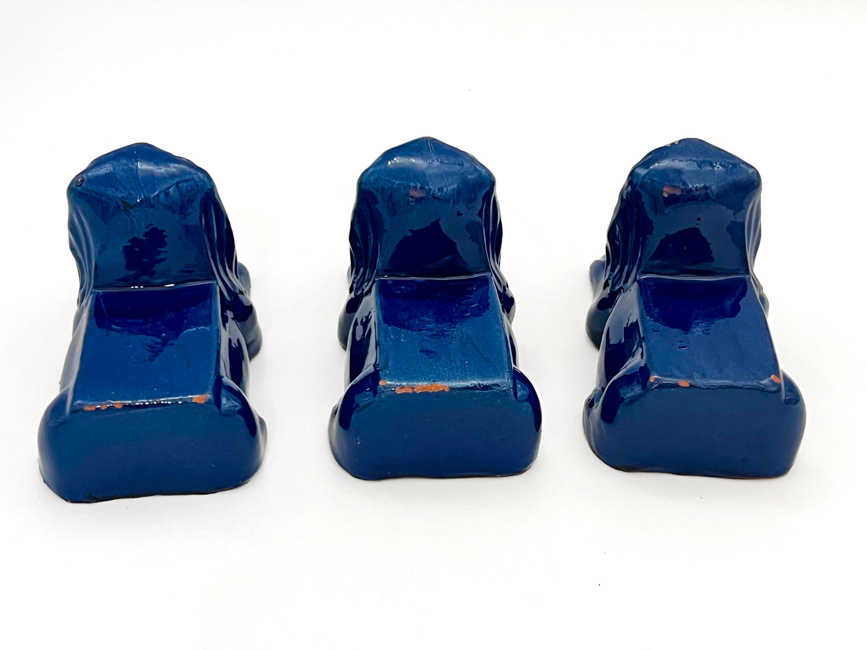Set of three decorative terra cotta lion sculptures in a unique petroleum blue glaze.